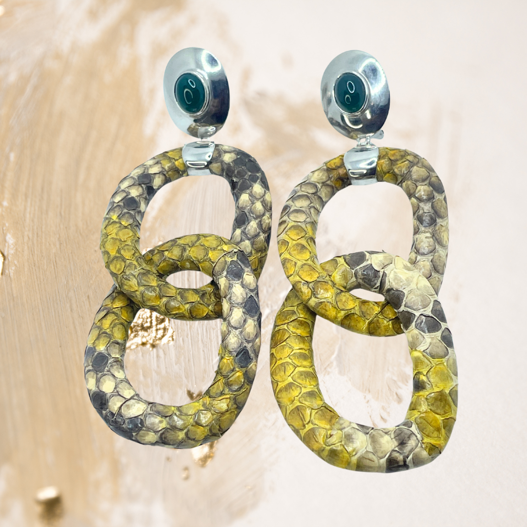 Os brincos de argolas em formato píton, esculpidos em prata, revelam um brilho sutil que valoriza cada detalhe do design.