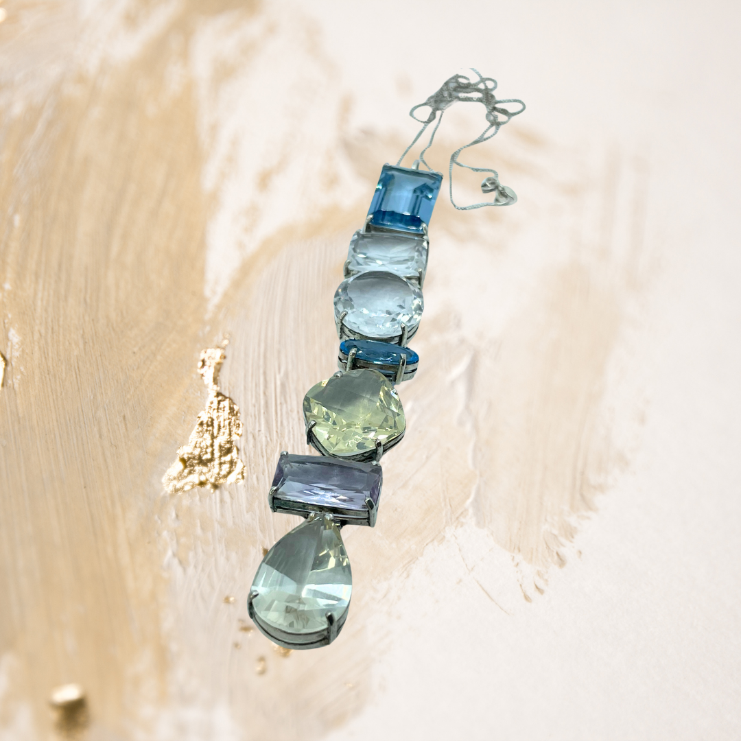 A gargantilha de cristais em tons de verde e ouro envolve o colo com um brilho delicado e envolvente.