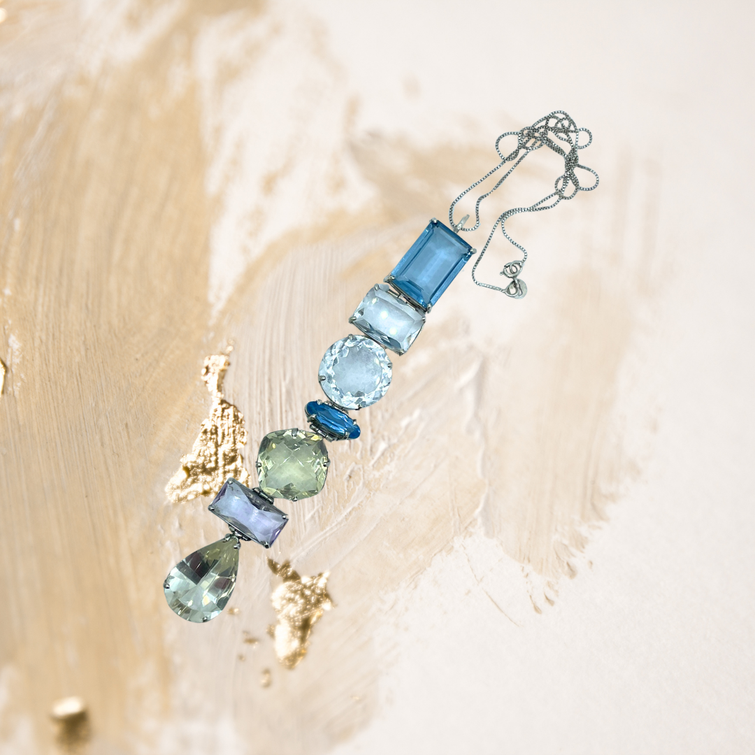 A gargantilha de cristais em tons de verde e ouro envolve o colo com um brilho delicado e envolvente.