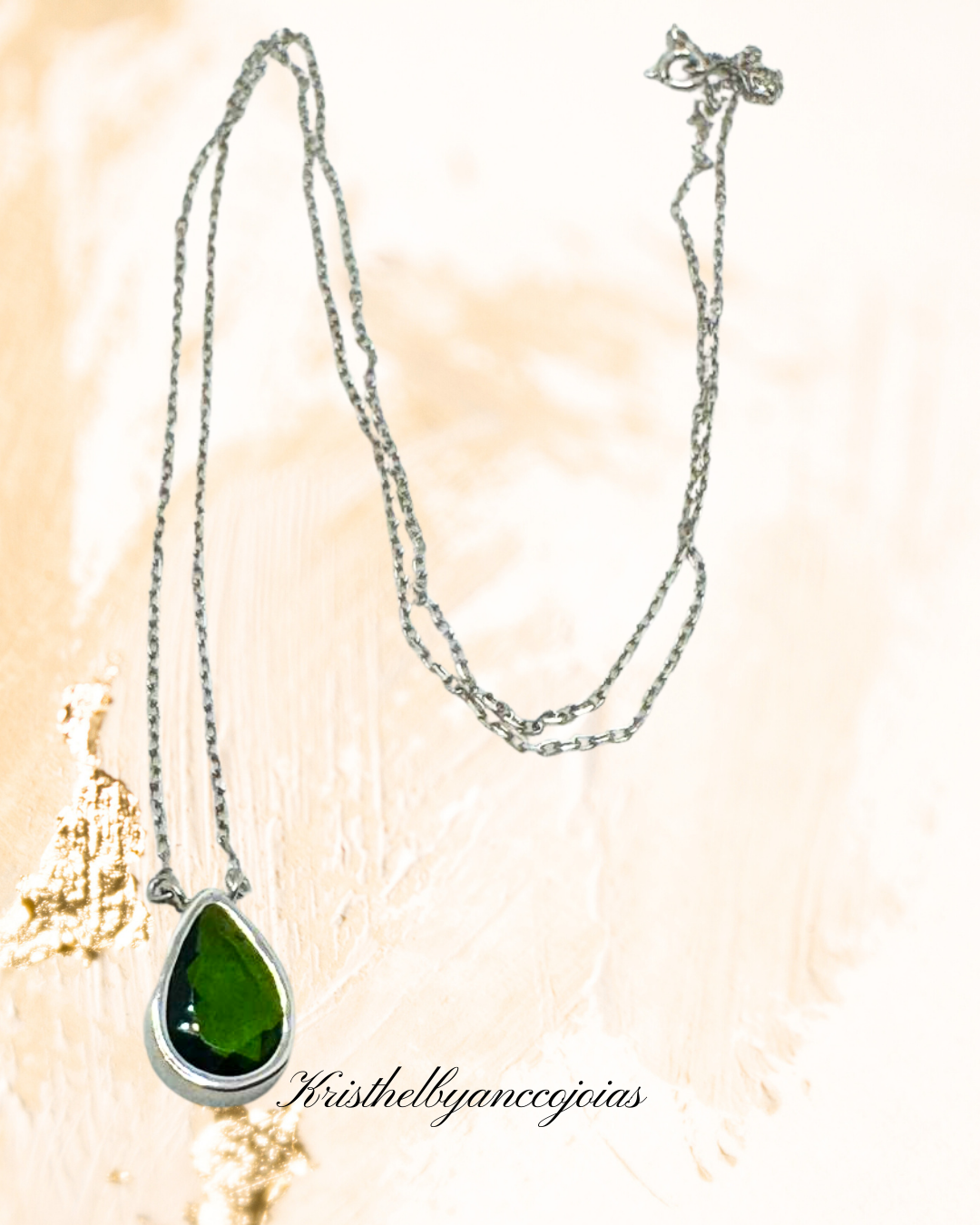  Um cordão com o encanto do topázio verde, lapidado em formato de gota, ganha destaque nessa peça em prata 950 com banho de ródio.