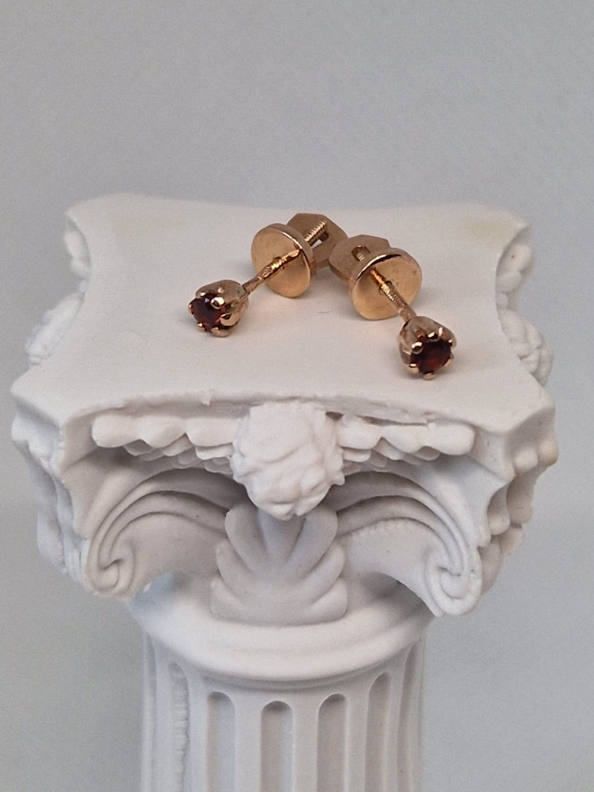 Gold stud earrings with red gemstones