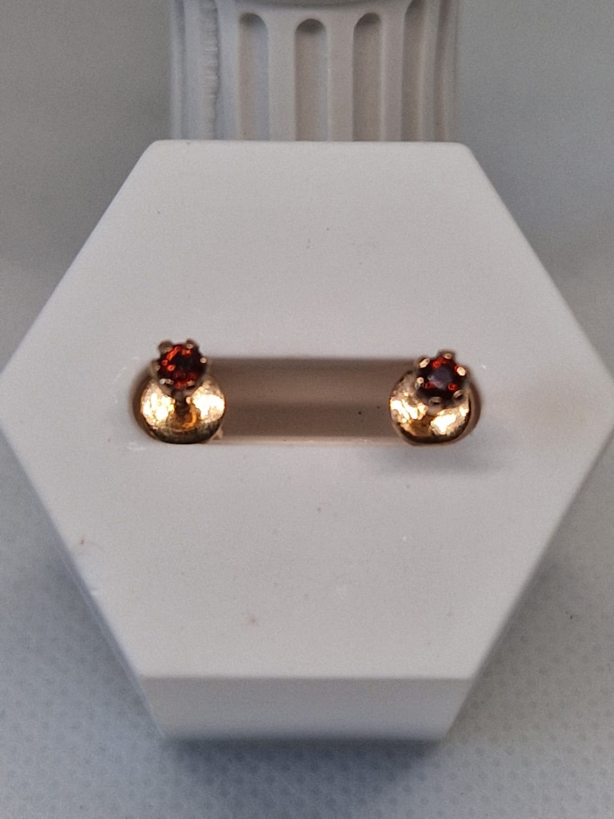 Gold stud earrings with red gemstones