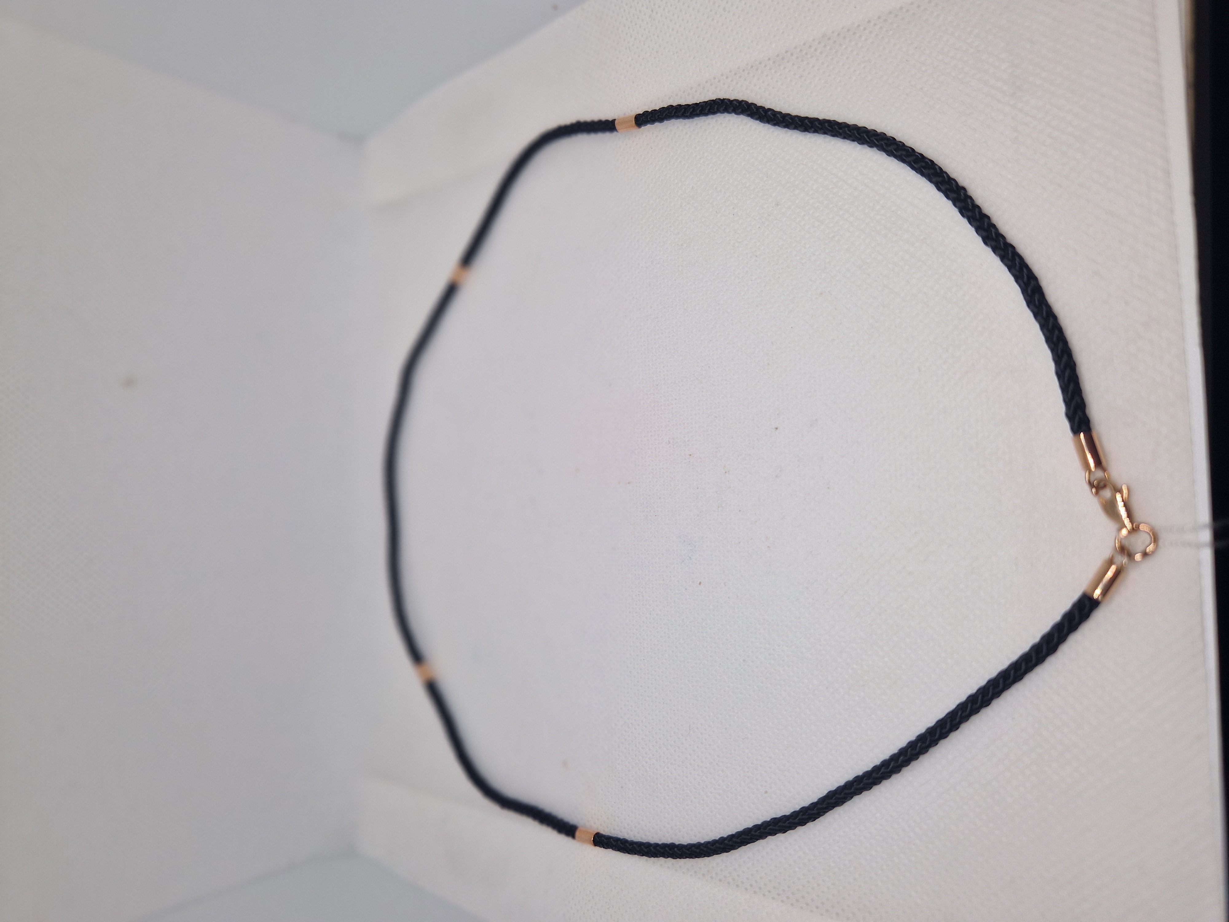 Black syntetic cord with gold insert and a lock