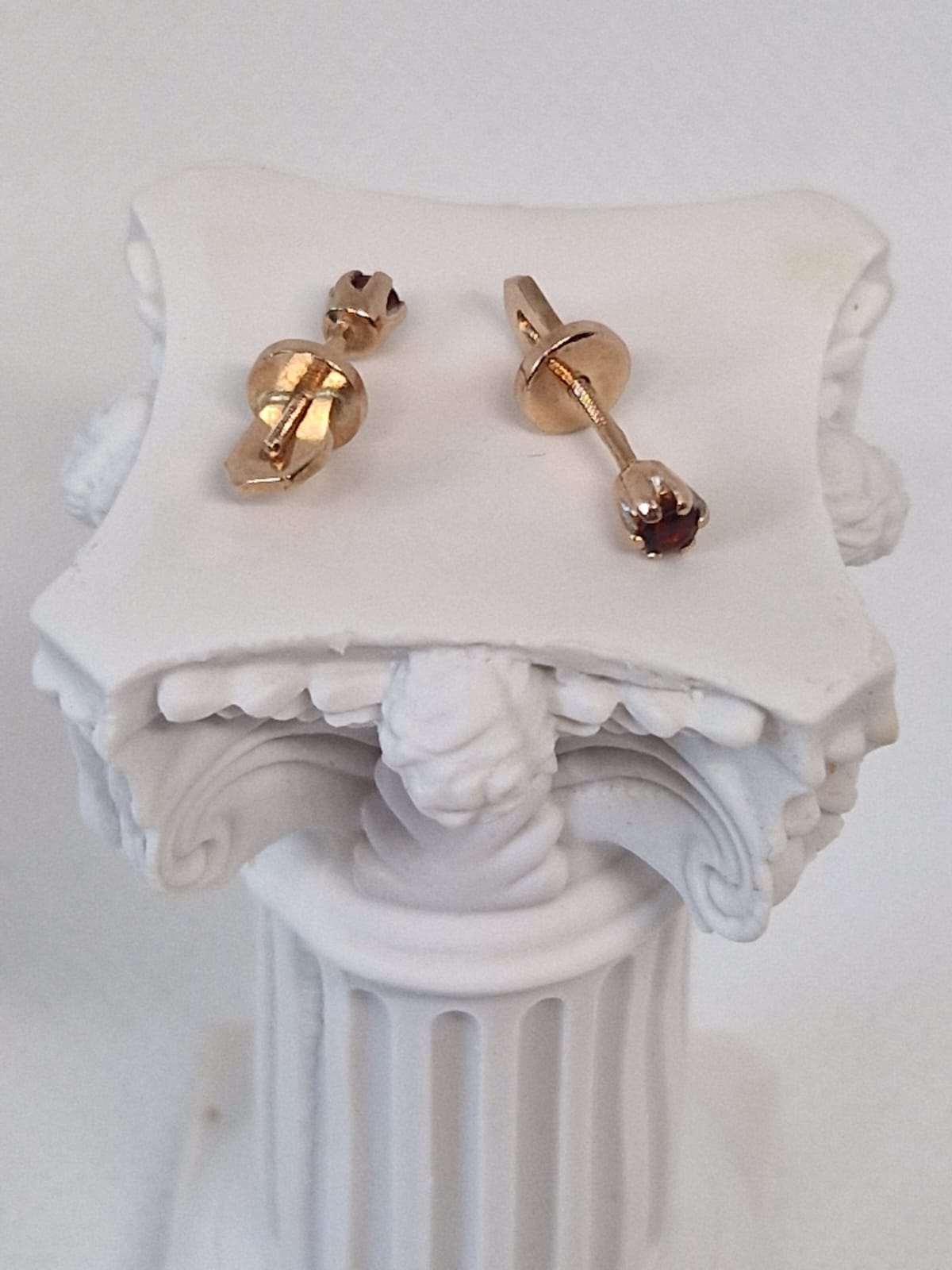 Gold stud earrings with red gemstones