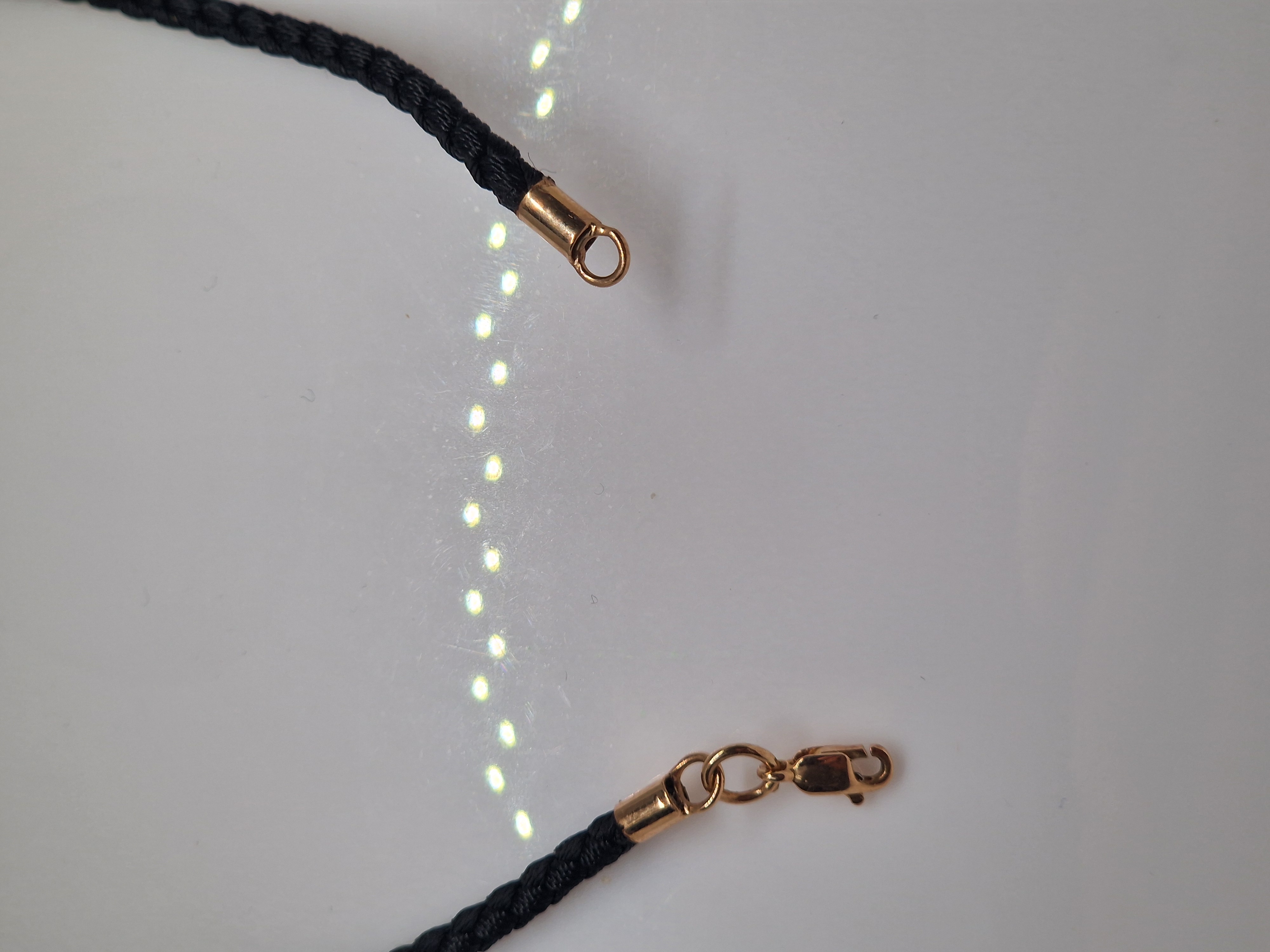 Black syntetic cord with gold ends and a lock