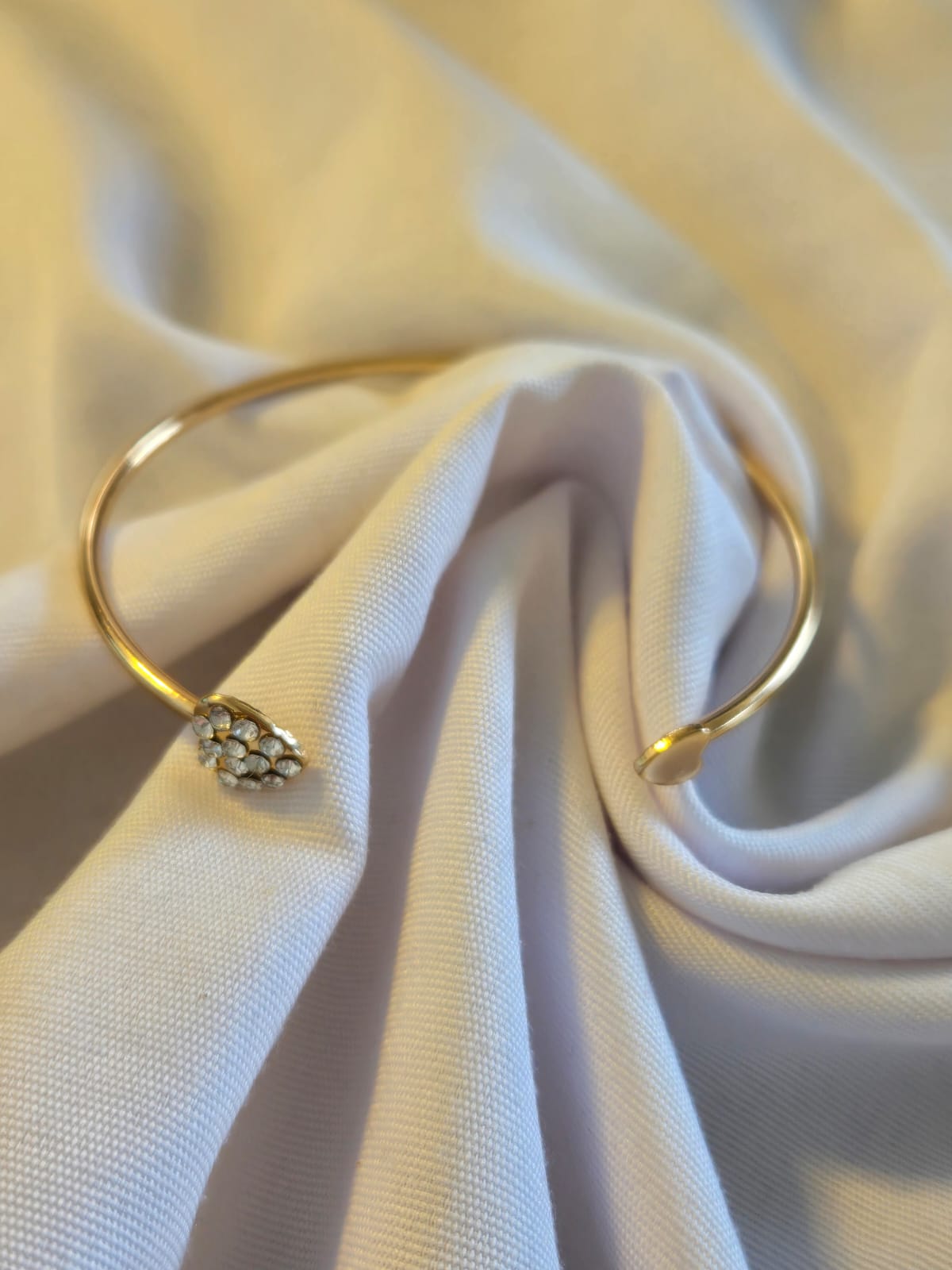Pulsera dorada con corazón de piedras