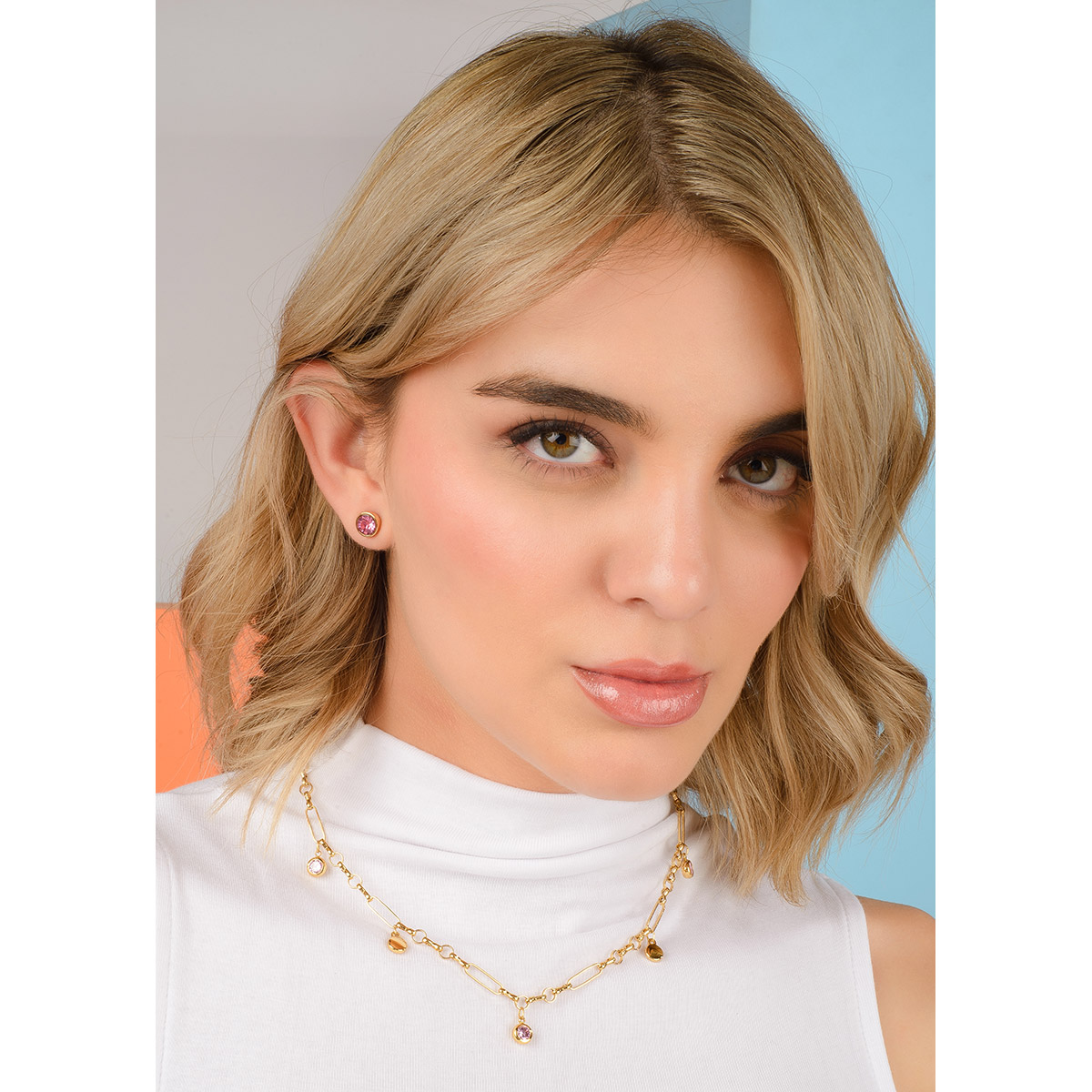 Aretes de botón en baño oro con piedra tono rosa