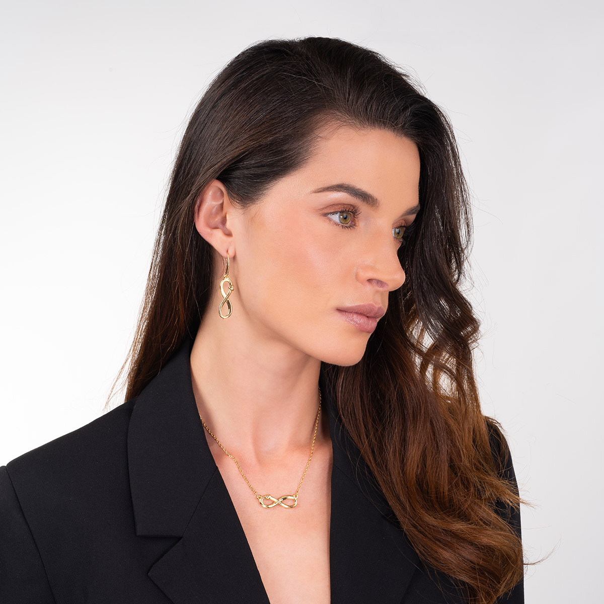 Aretes en baño de oro con símbolo infinito y detalle pulido