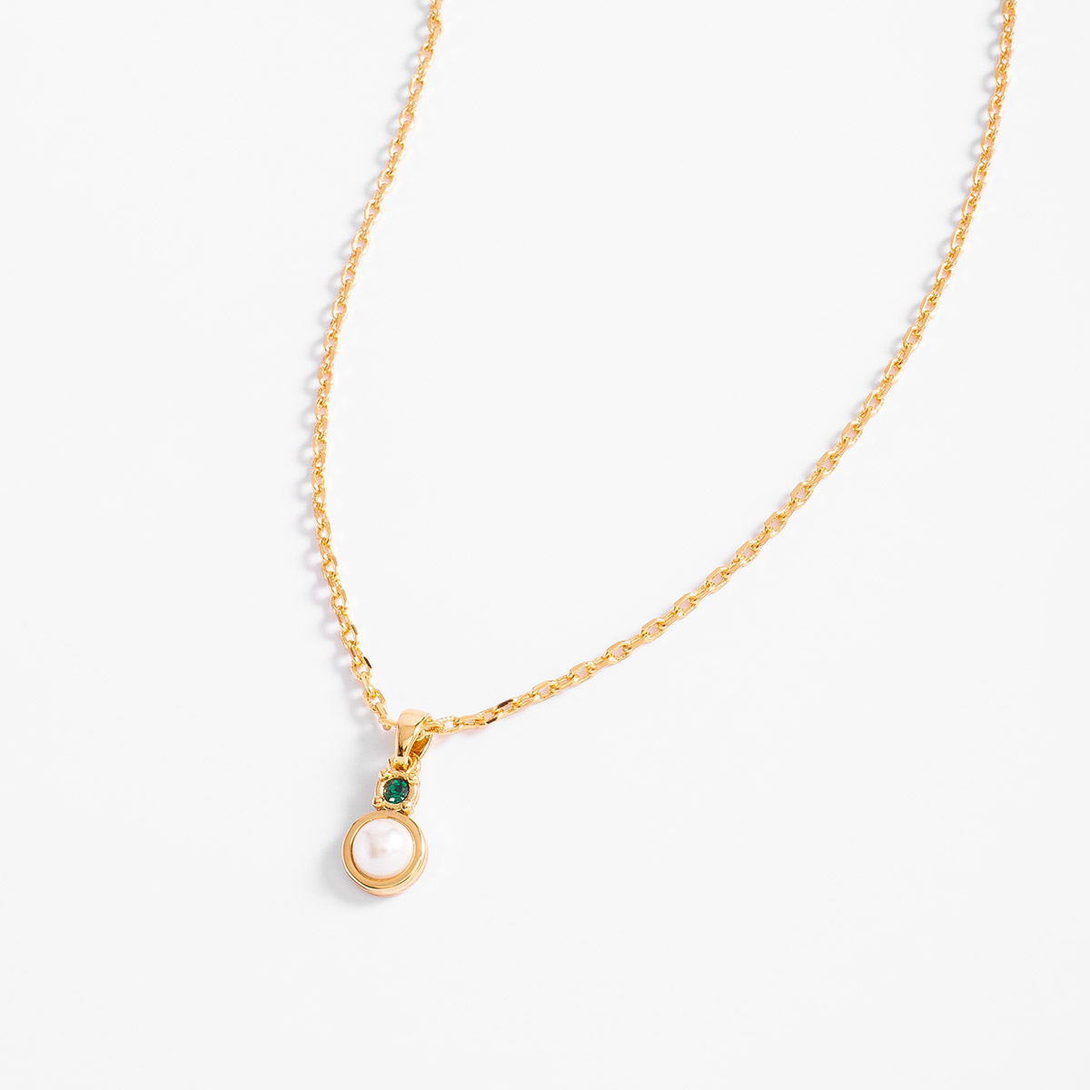 Collar con perla tono crema y cristal verde en baño de oro