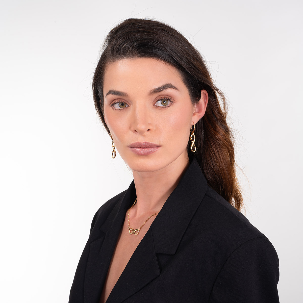 Aretes en baño de oro con símbolo infinito y detalle pulido