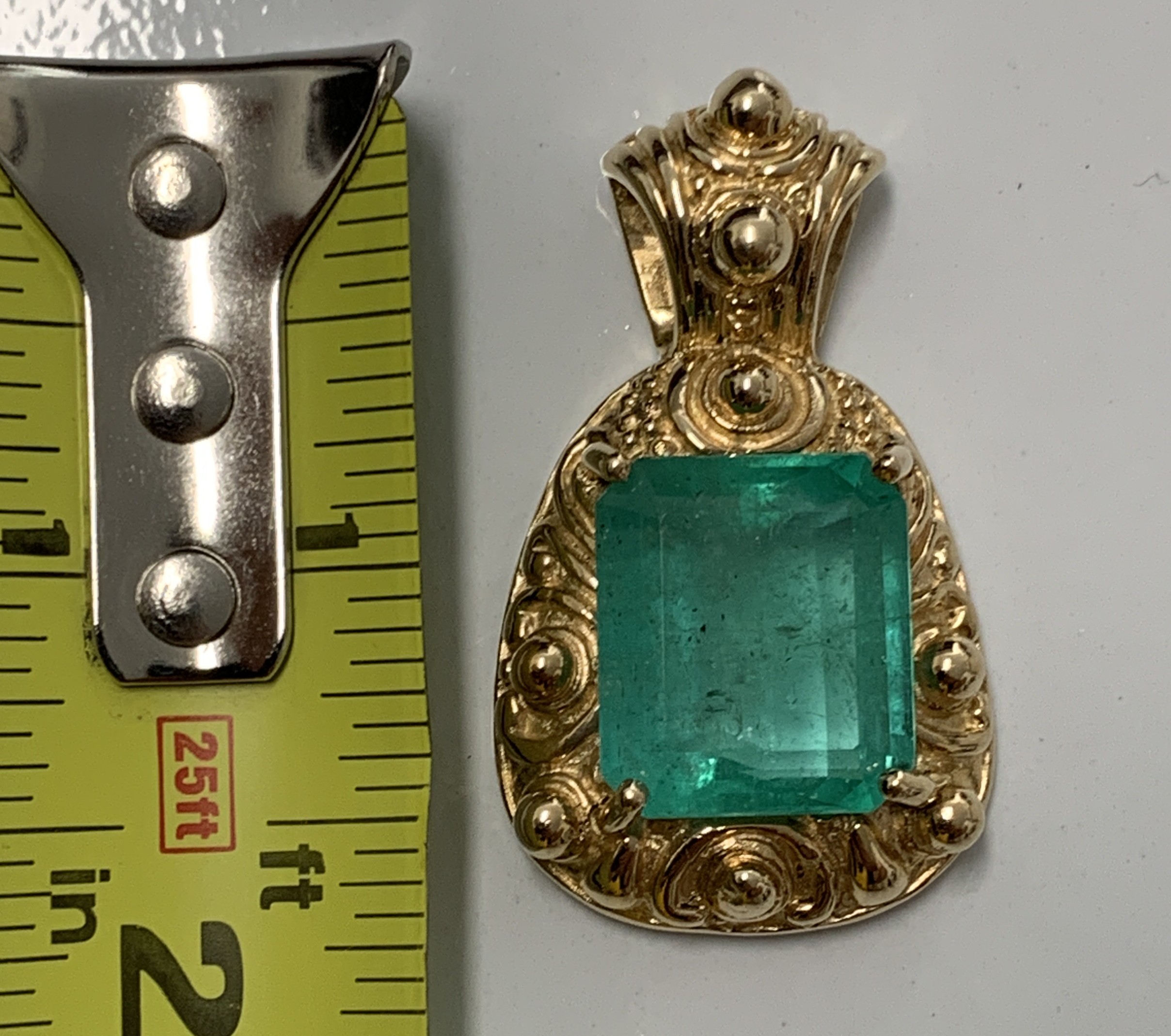 18.02ct. Natural Emerald cut Emerald set in a 14K yellow gold pendant