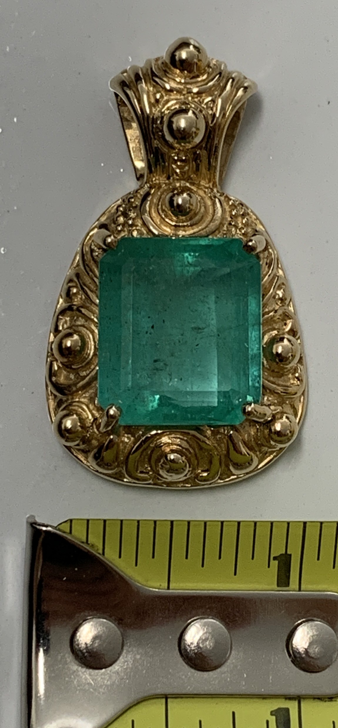 18.02ct. Natural Emerald cut Emerald set in a 14K yellow gold pendant