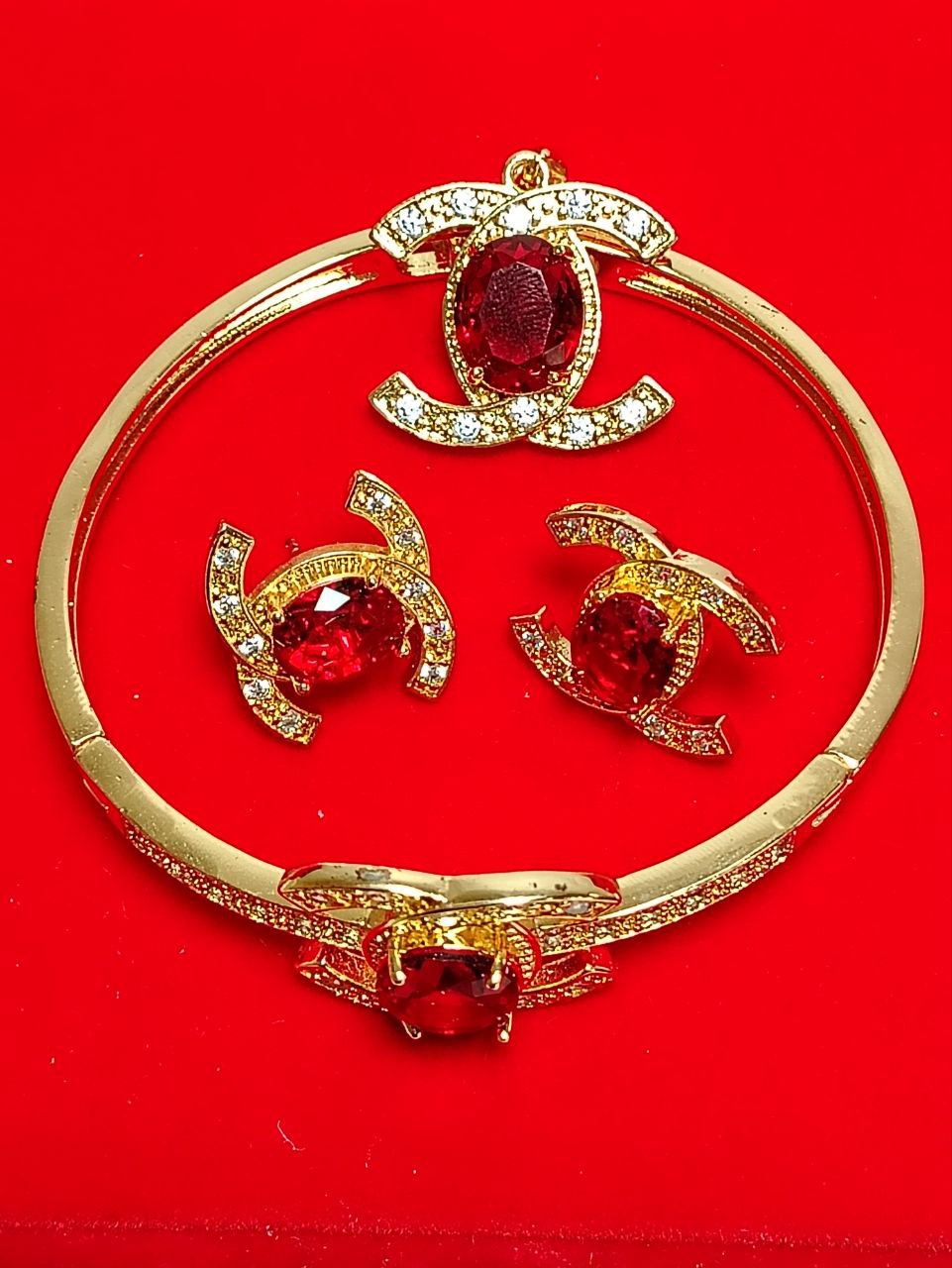 Juego de joyas doradas con piedras rojas