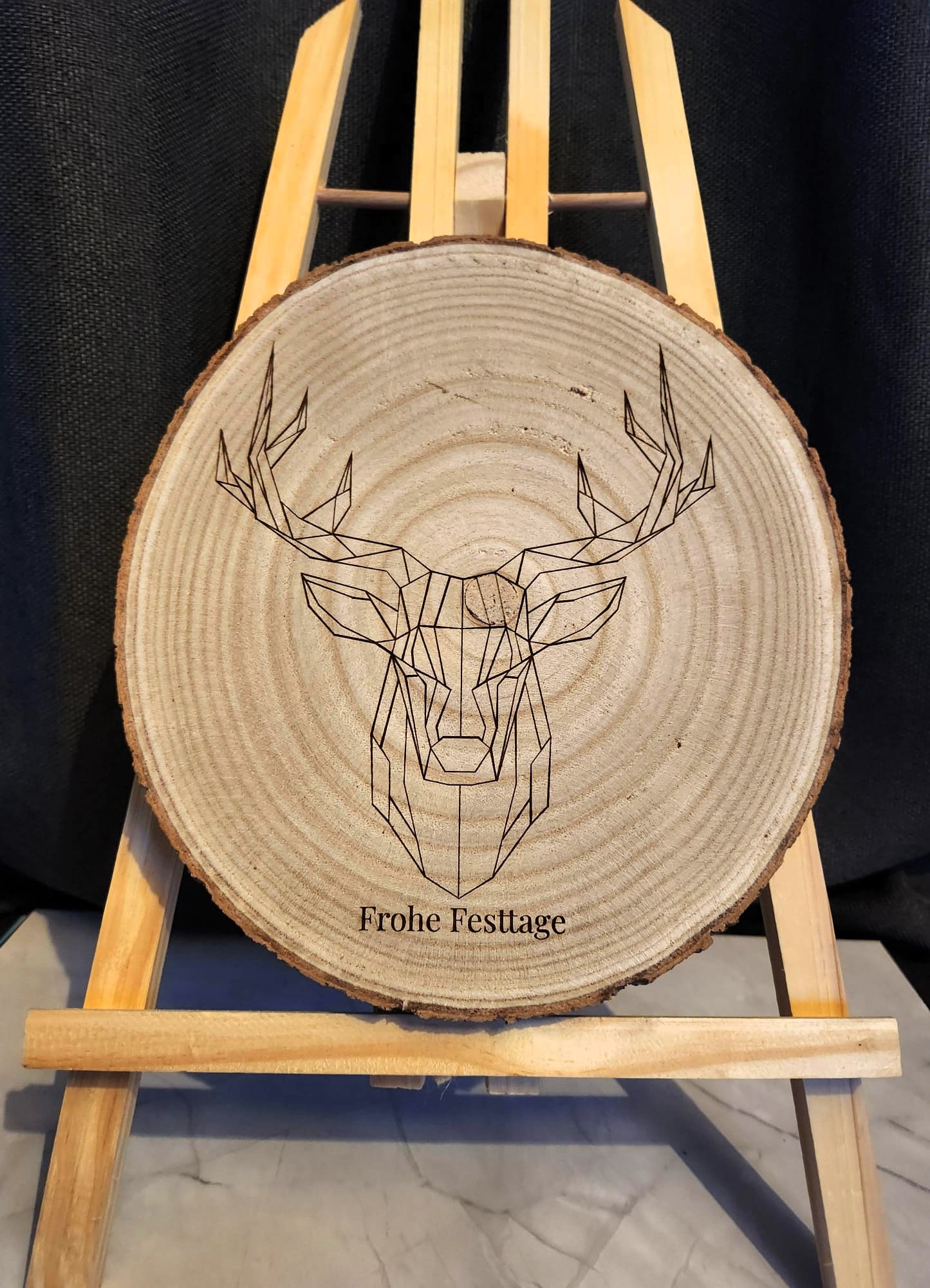 Holzscheibe mit Lasergravur „Geometrischer Hirsch – Frohe Festtage“