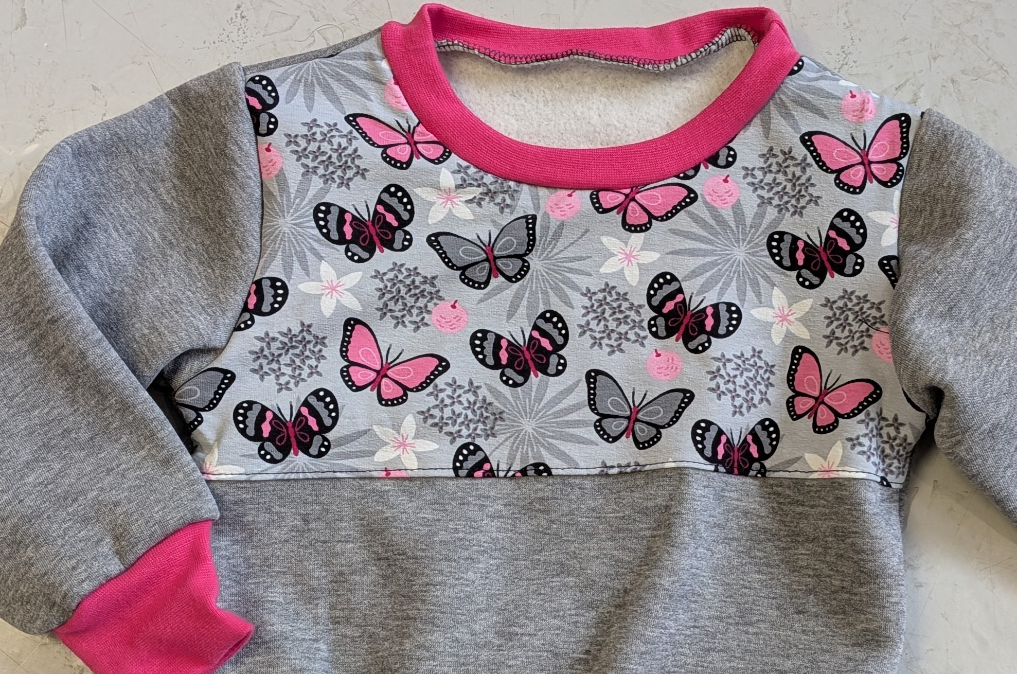 Kinderpullover mit Schmetterlingsmuster in den Größen 74/80 bis 134 aus Jerseystoff 