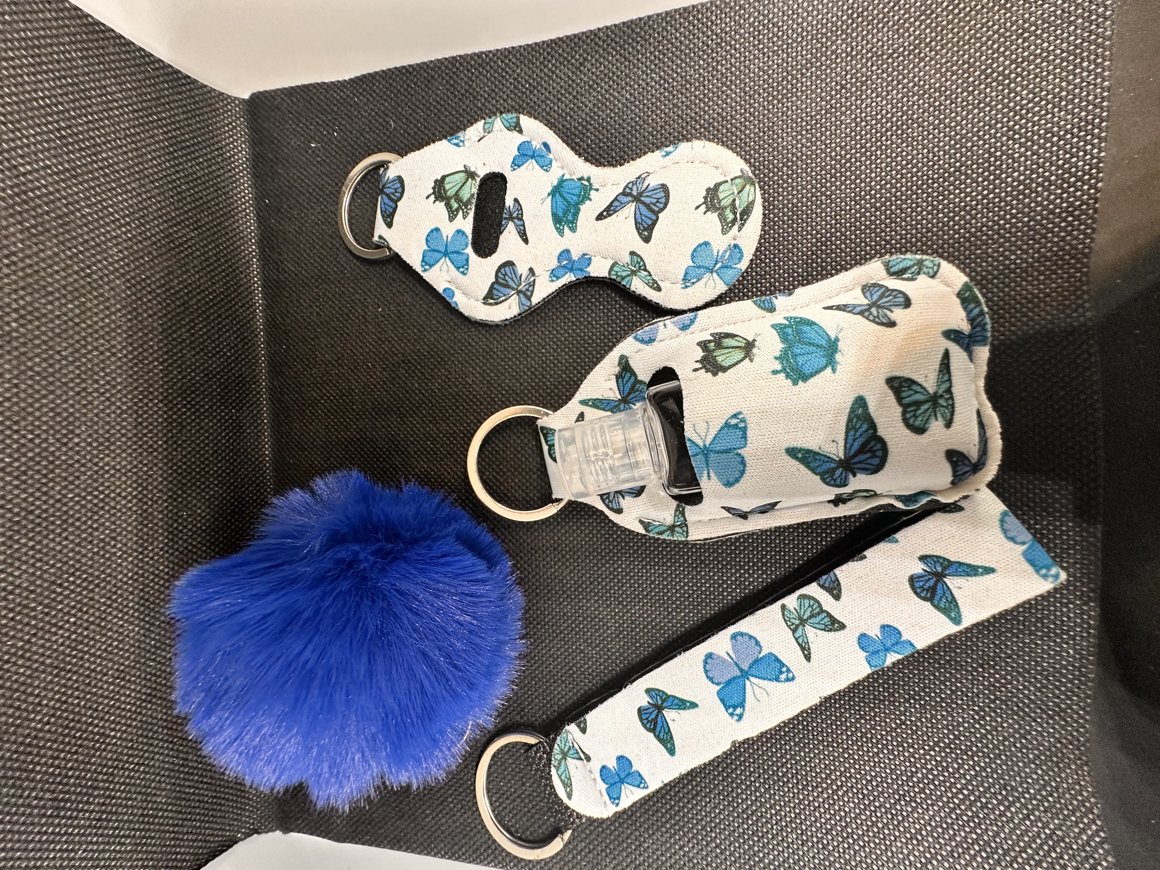 Blue butterfly lipstick holder, sanitiser bottle and pompom keychain