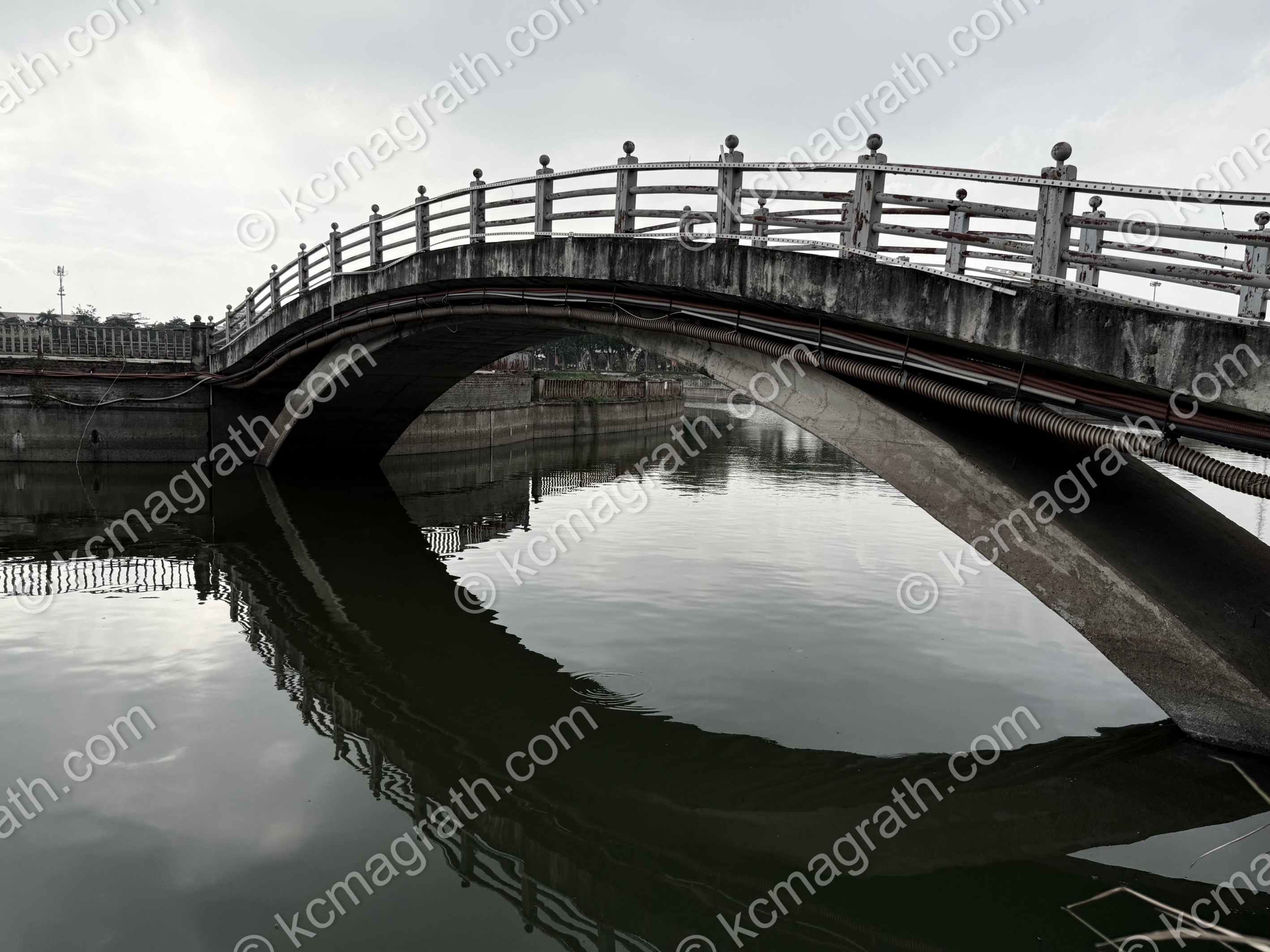 Vinh Yen's Bridge Over Vac Lagoon With Reflection Forming "Eye", B&W, Vietnam