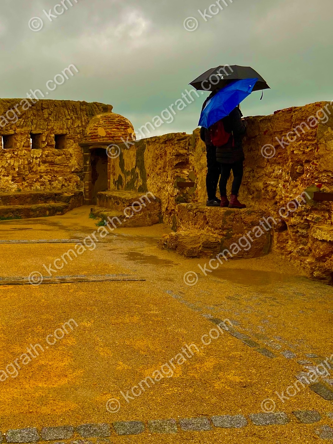 Cadiz's Castillo de Santa Catalina on a Rainy Day with Couple Under Umbrella, Spain