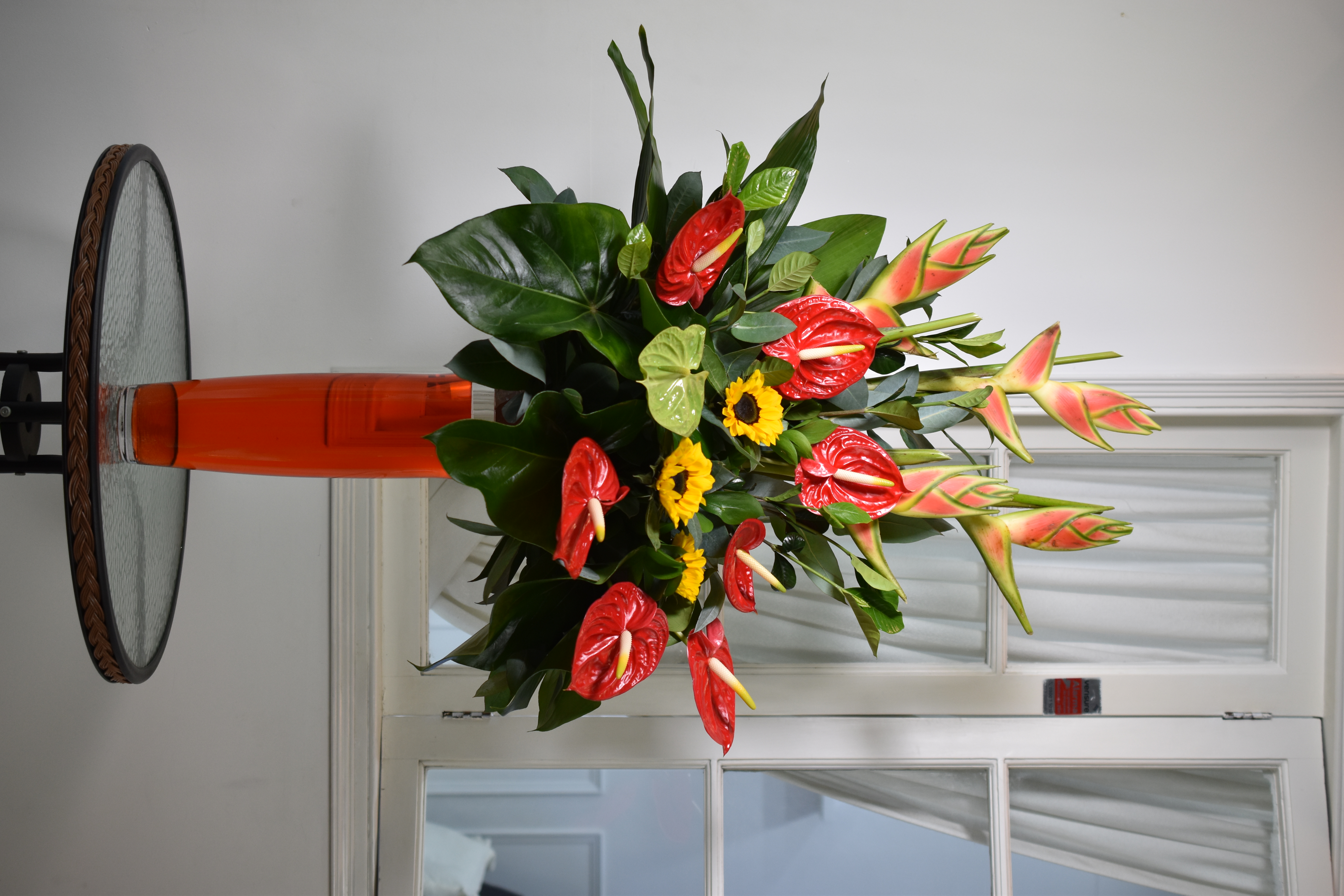 Arreglo floral de anturios, girasoles y Heliconias