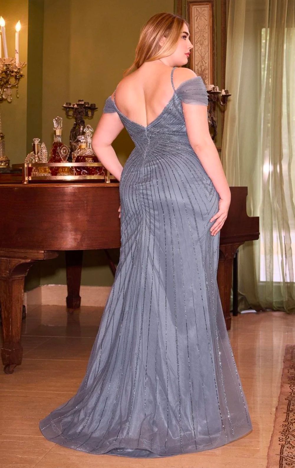 Vestido de ñoche de gala color girs con abertura alta en una pierna. 