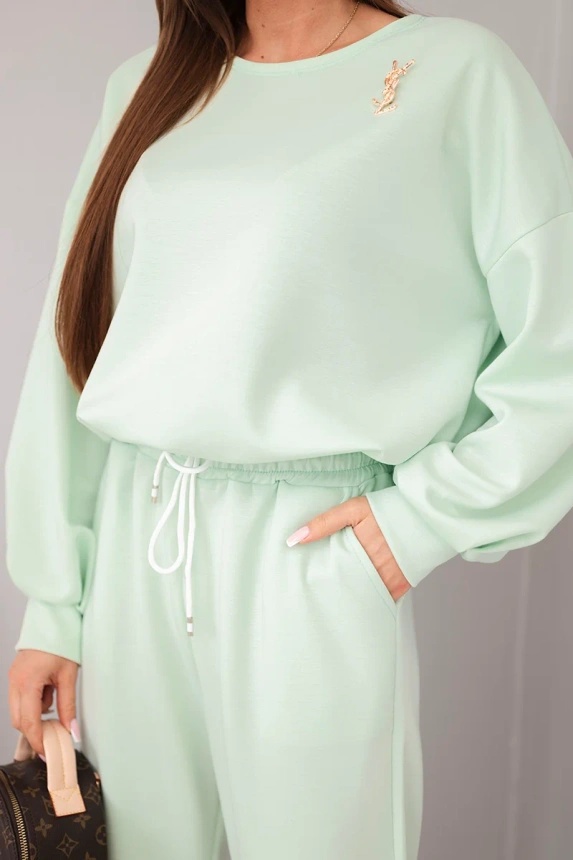 Miętowy dres z broszką