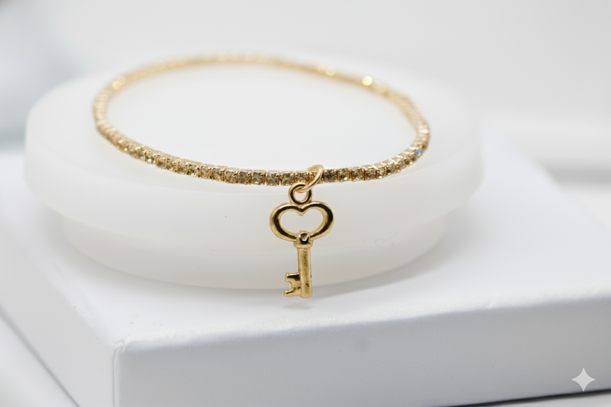 Pulsera dorada de brillos y con dije de llave
