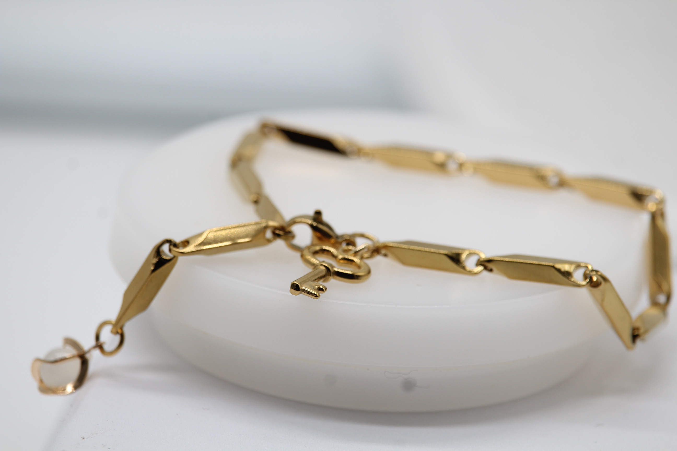 Pulsera de eslabones geométricos y llave dorada