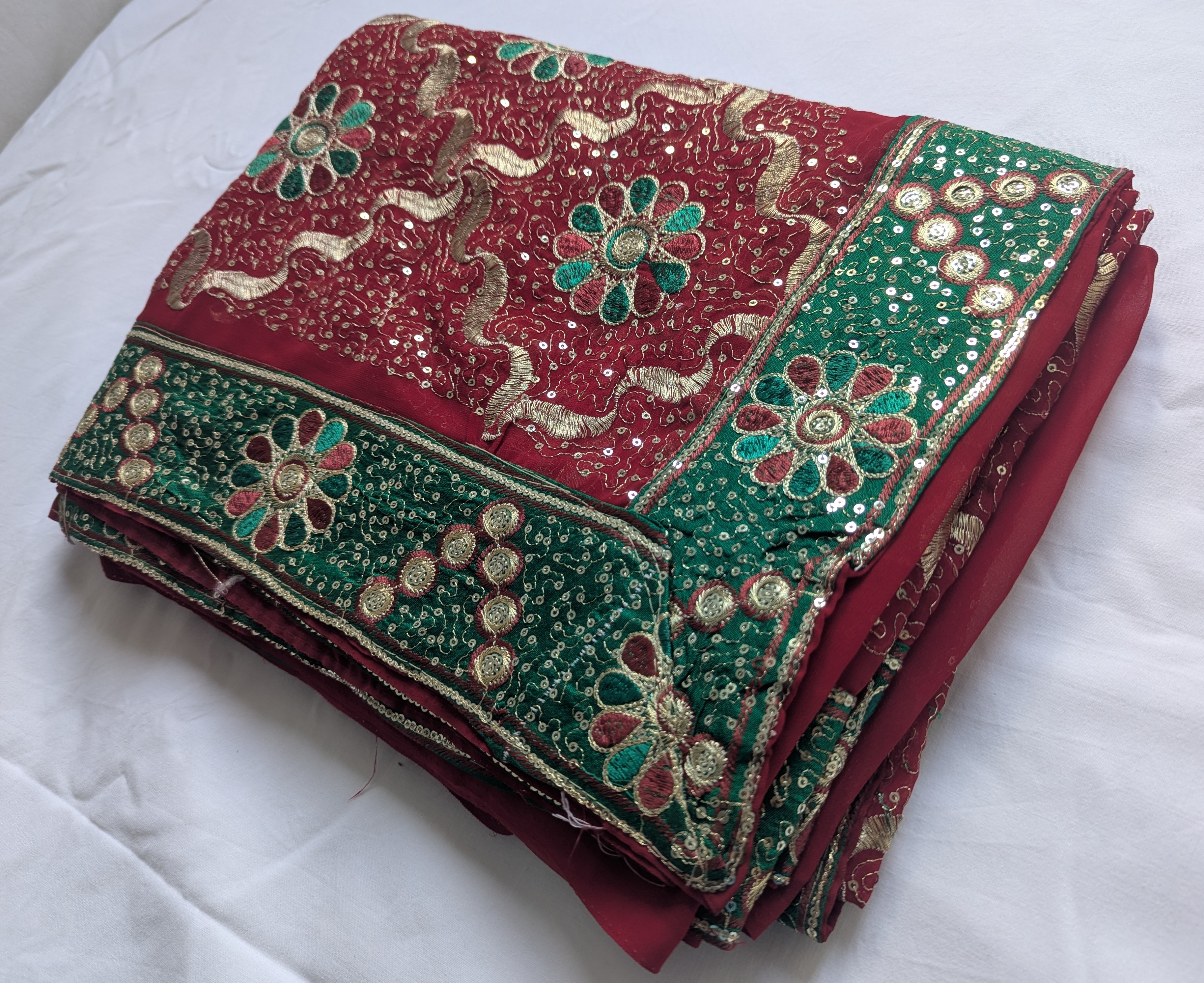 Roter Saree mit grünen Stickereien und mit goldenen Akzenten