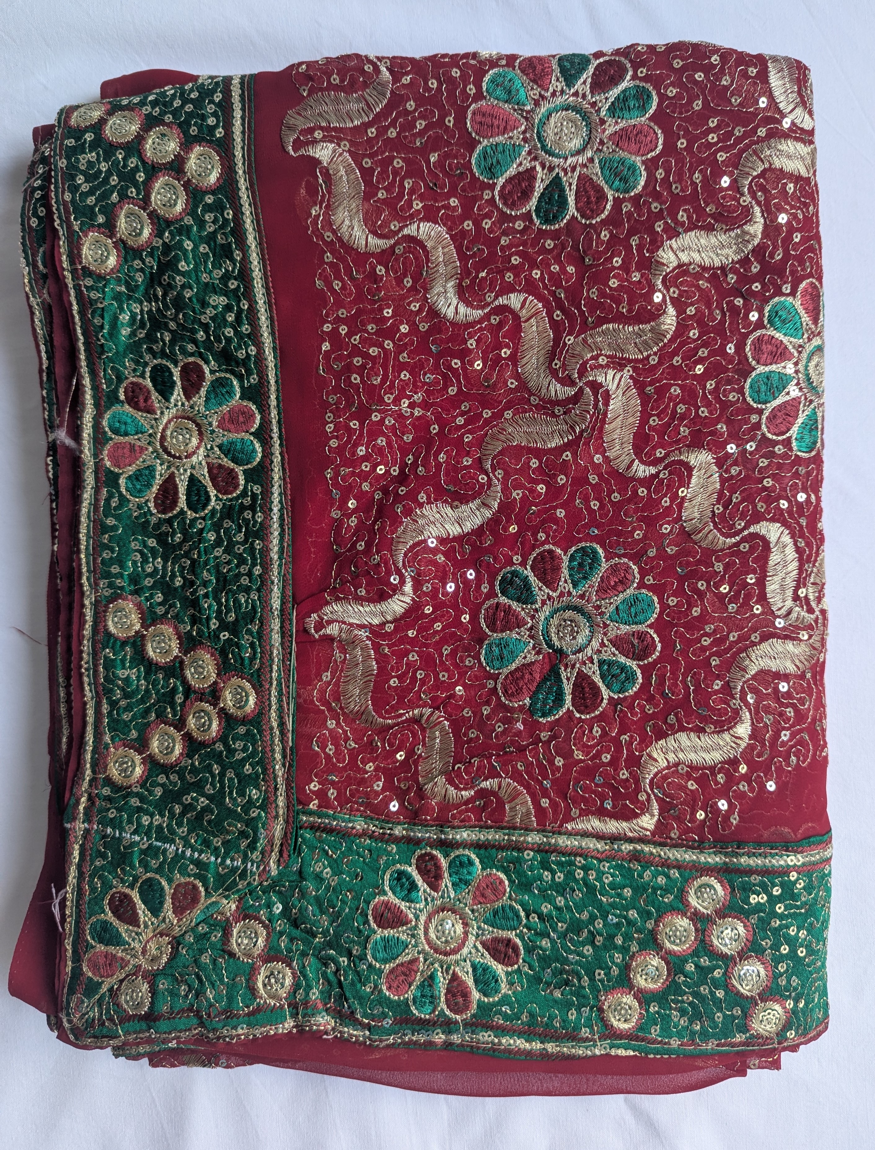 Roter Saree mit grünen Stickereien und mit goldenen Akzenten