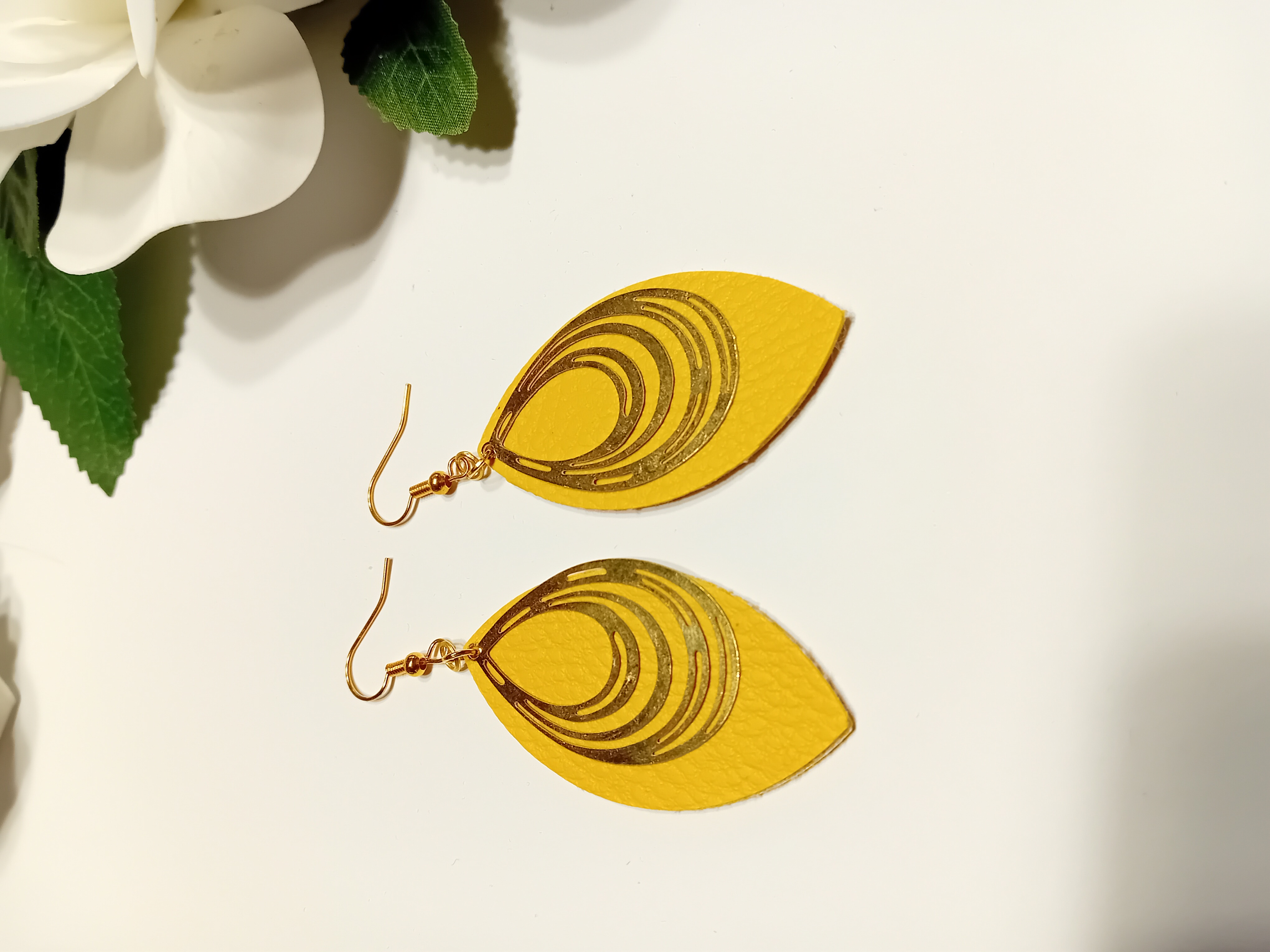 Boucle d'oreille en forme ovale cuir jaune et filigrane dorée