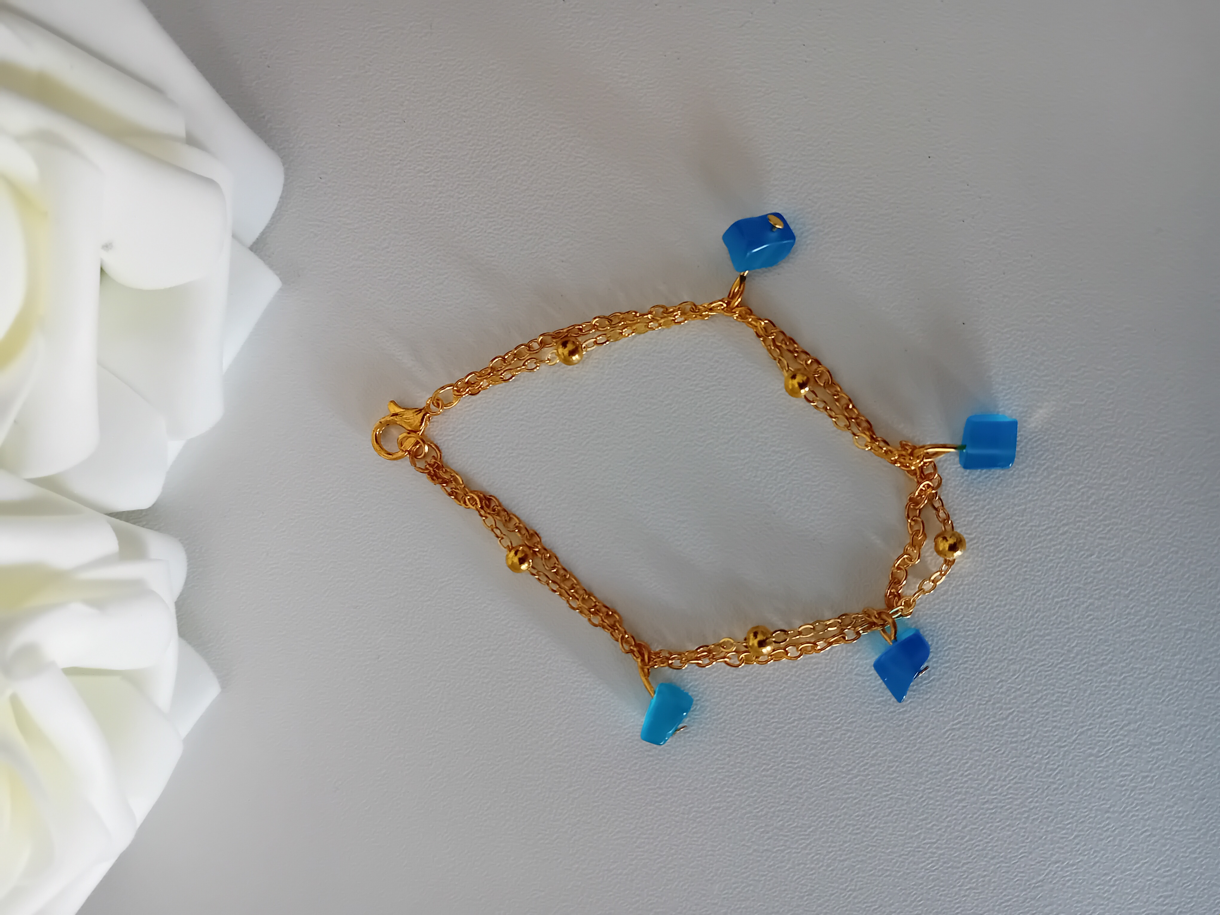 Bracelet en or avec pierres bleues et ses deux chaînes dorées. Bijou élégant
