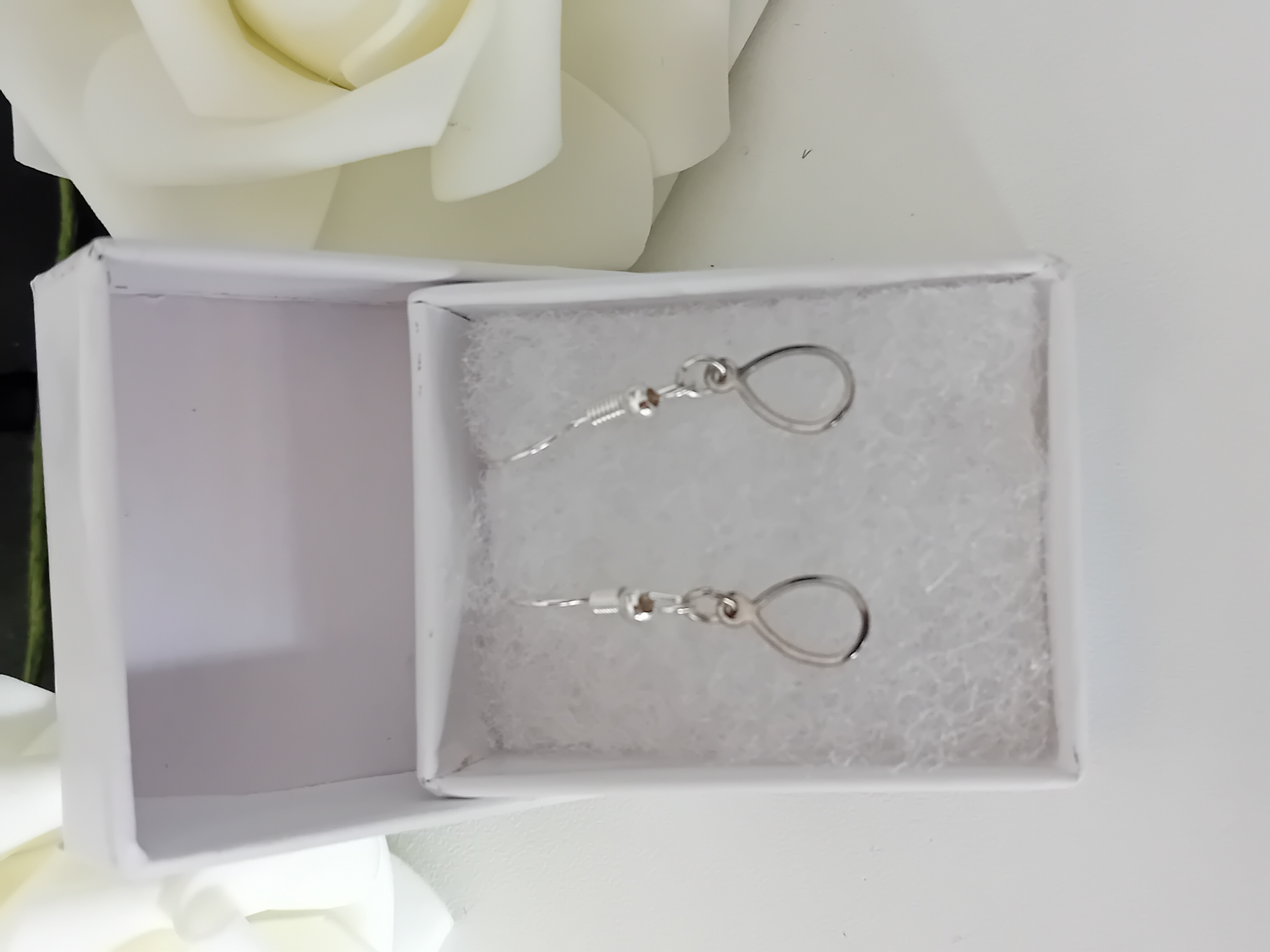 Boucles d'oreilles en argent en forme de ballon oval. Elégance discrète dans un coffret blanc