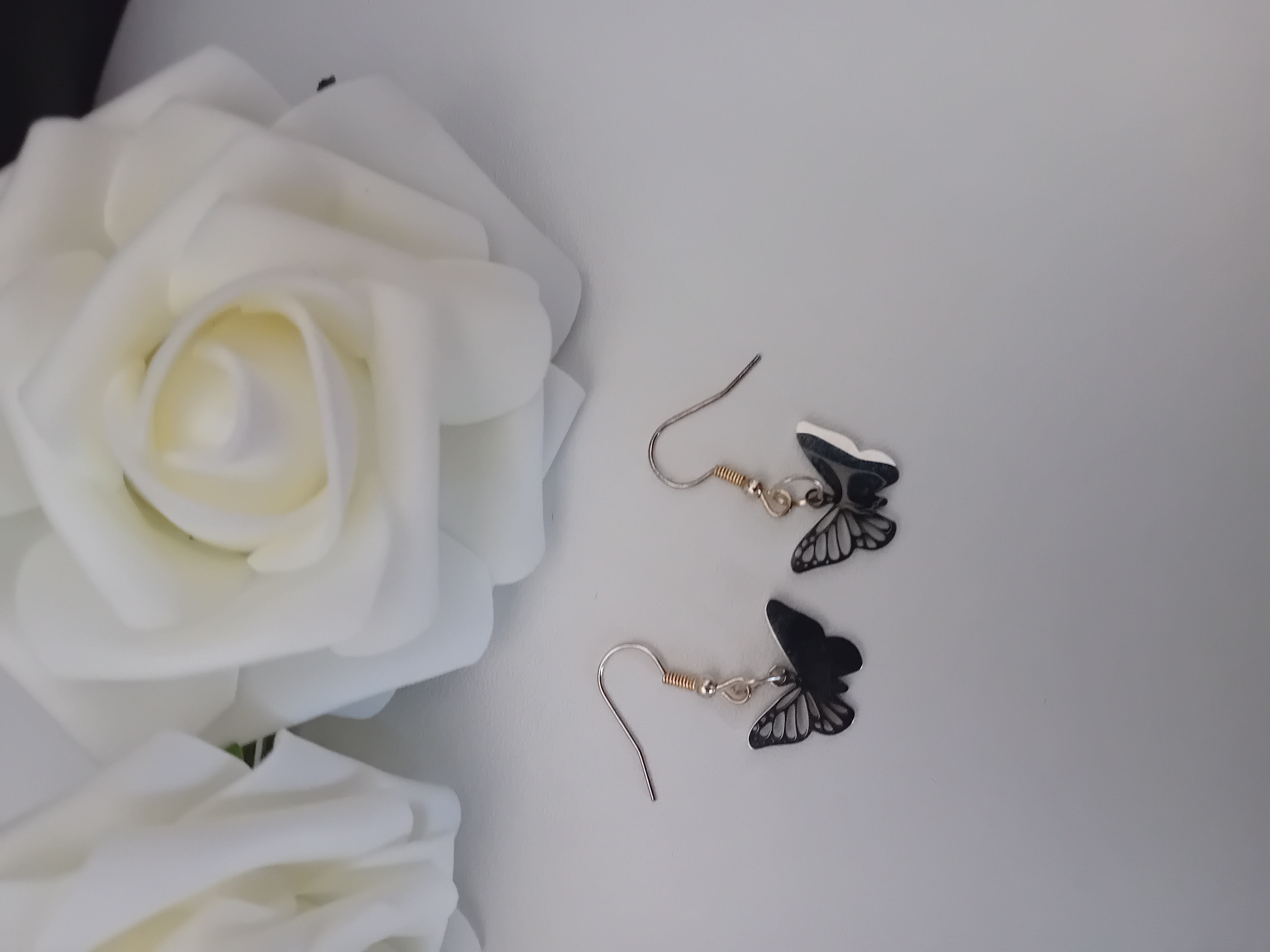 Ensemble collier et boucle d'oreille papillon argentée.