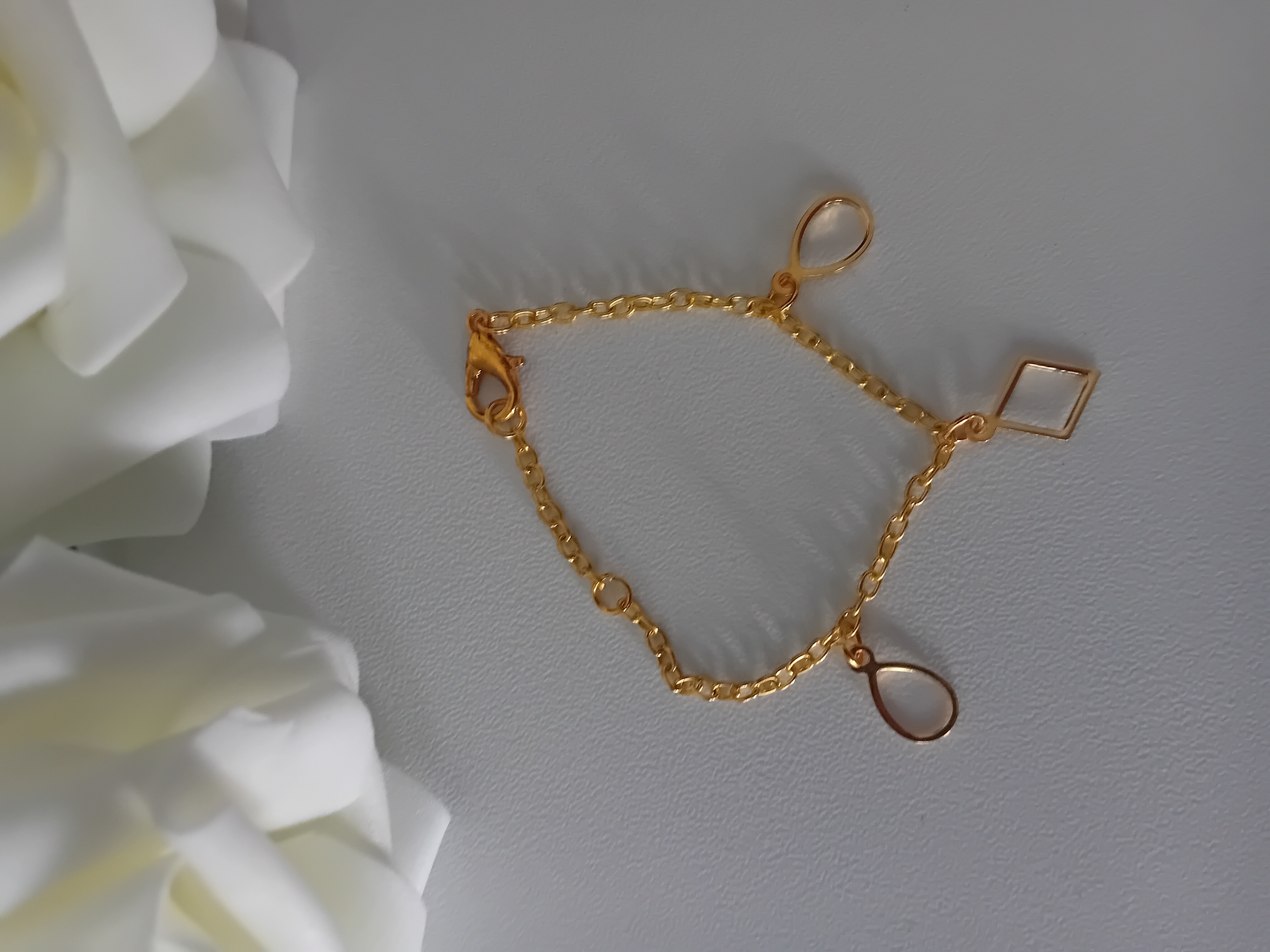 Bracelet en or. Bijou élégant avec pendentifs géométriques.