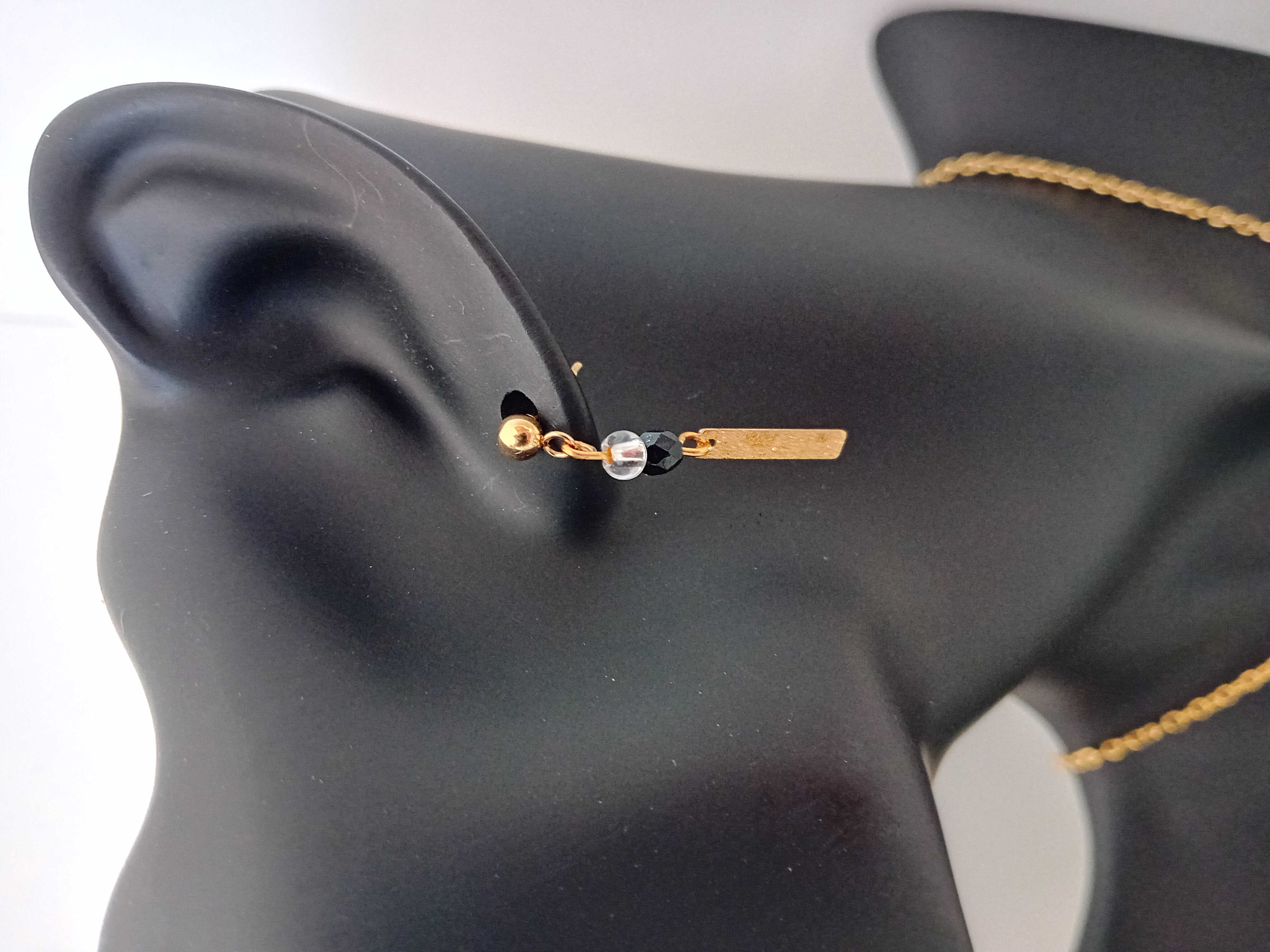 Boucles d'oreilles dorées et perle noire et transparente