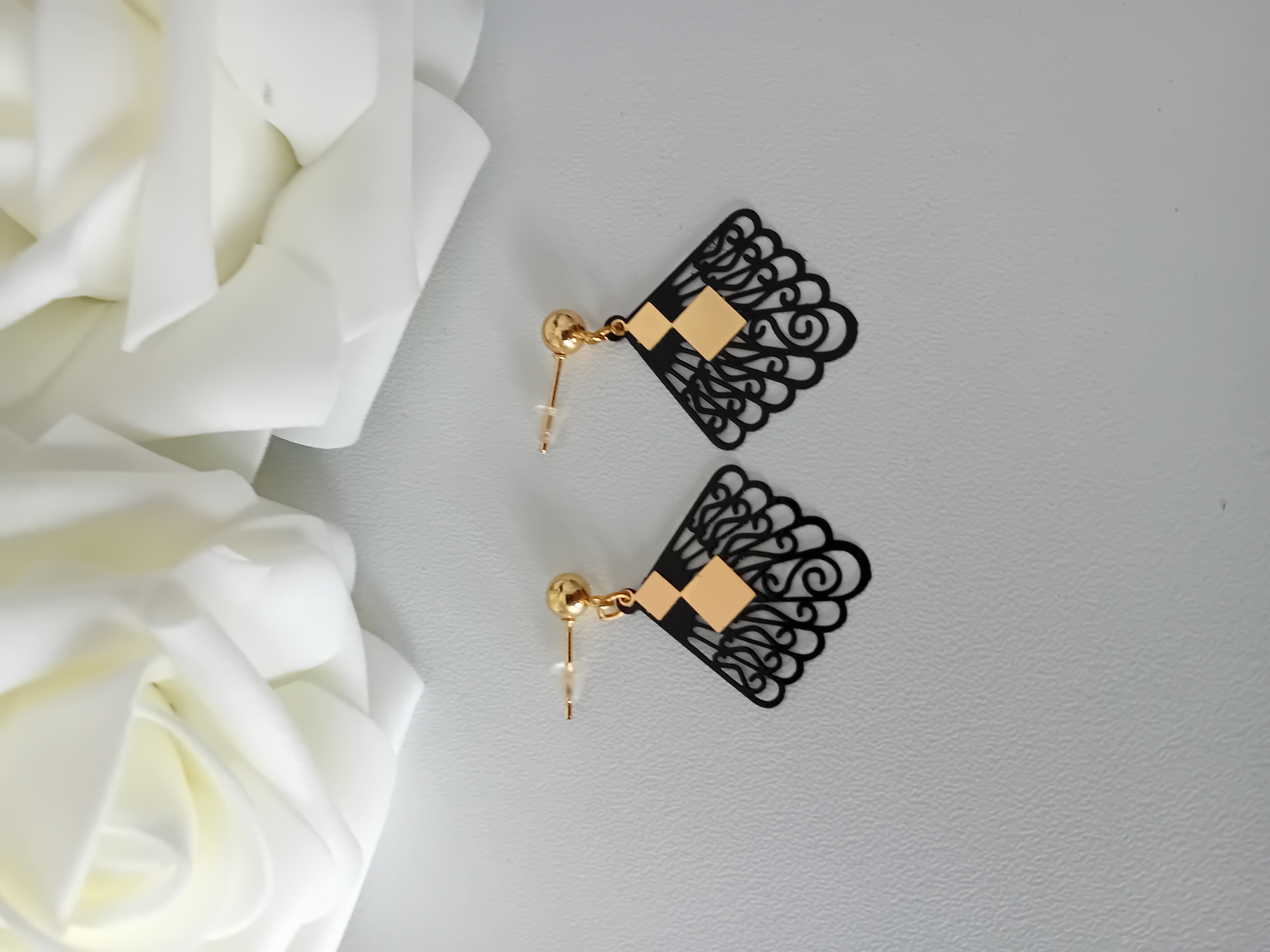 Boucles d'oreilles en dentelle noire avec des losanges accrochés. Elégance et originalité