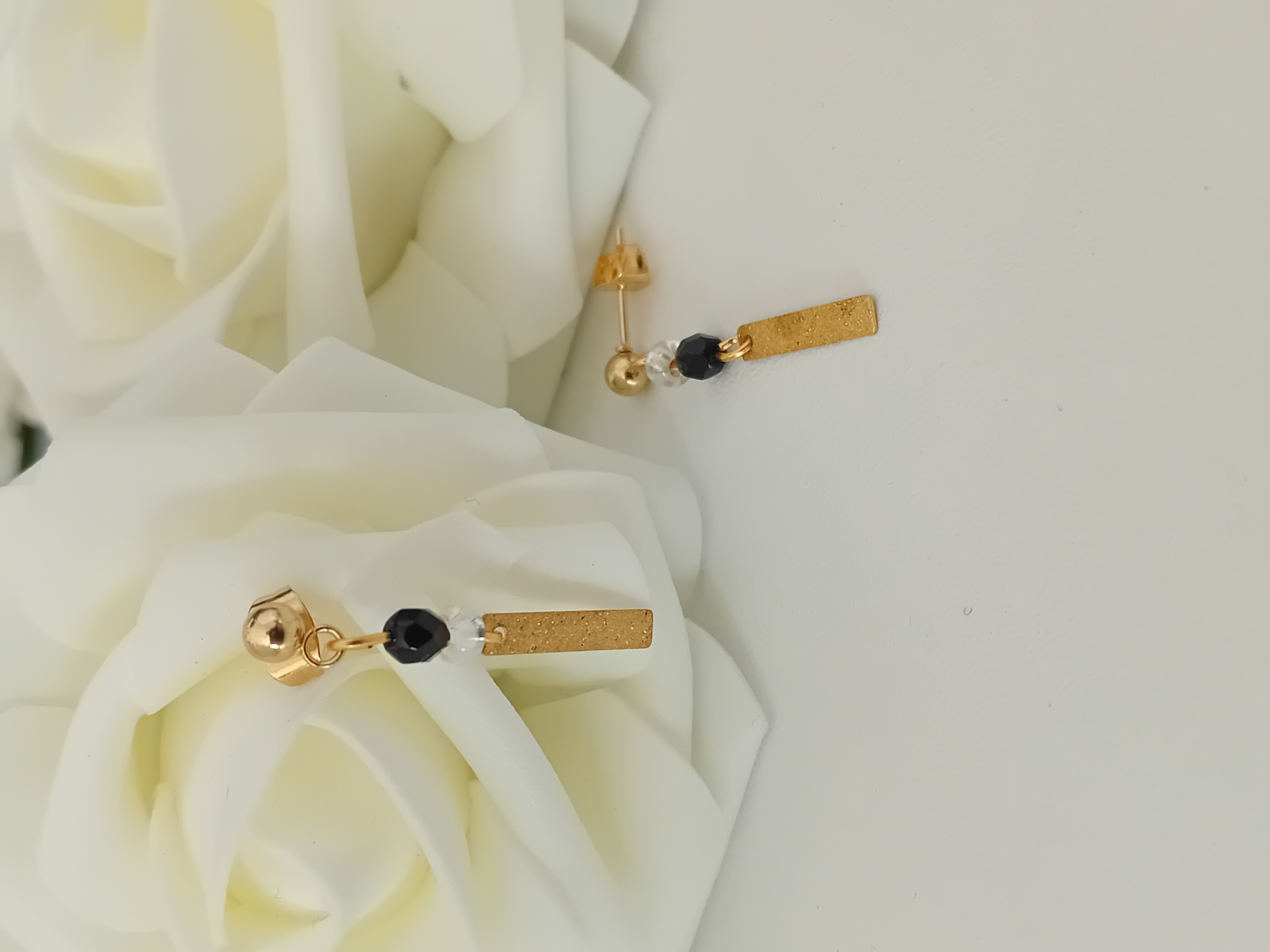 Boucles d'oreilles dorées et perle noire et transparente