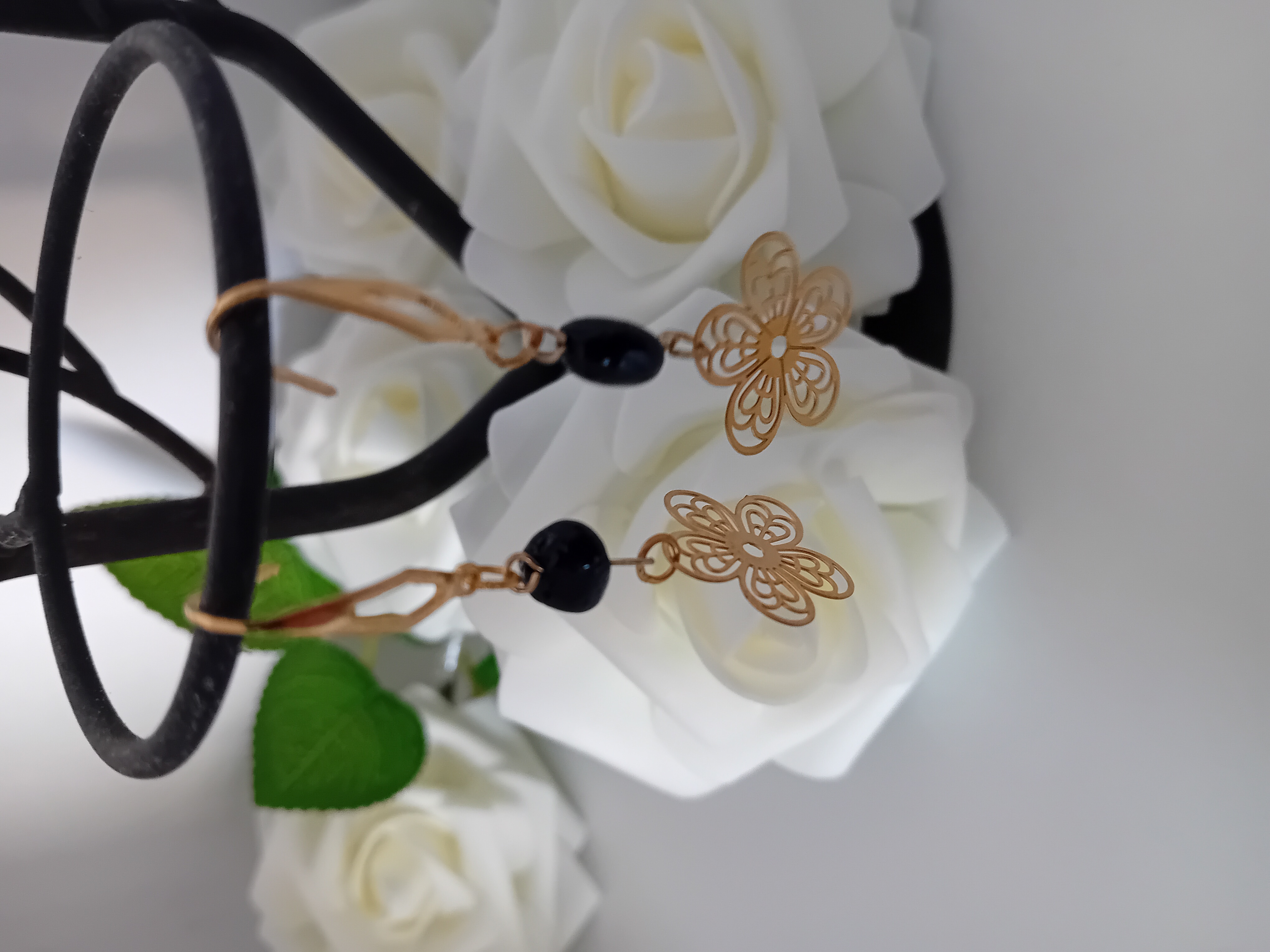 Boucles d'oreilles fleur dorées et perle naturelle noire. Elégance et raffinée