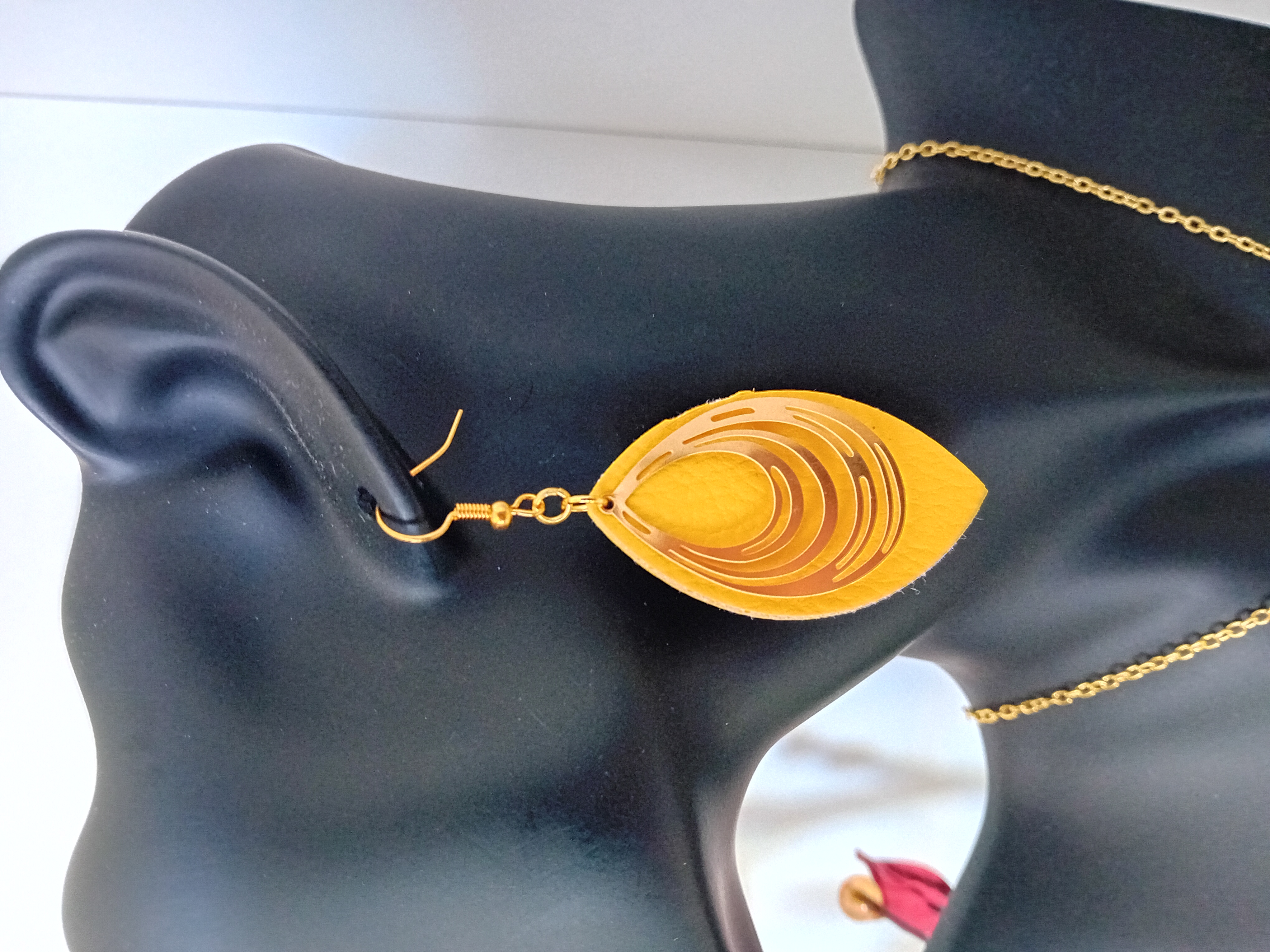 Boucle d'oreille en forme ovale cuir jaune et filigrane dorée