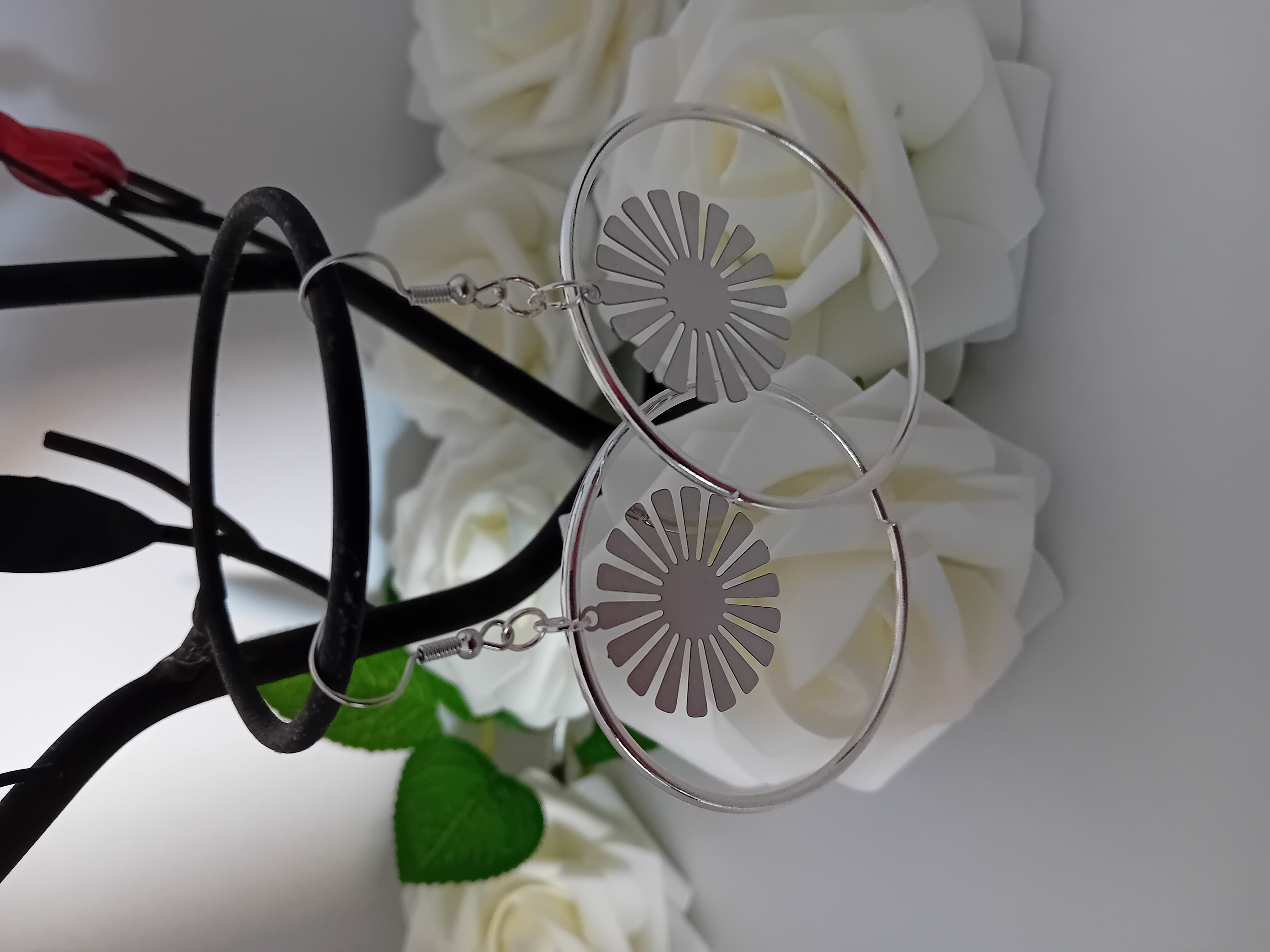 Boucles d'oreilles cercle argenté et une fleur argentée le tout dans un design moderne