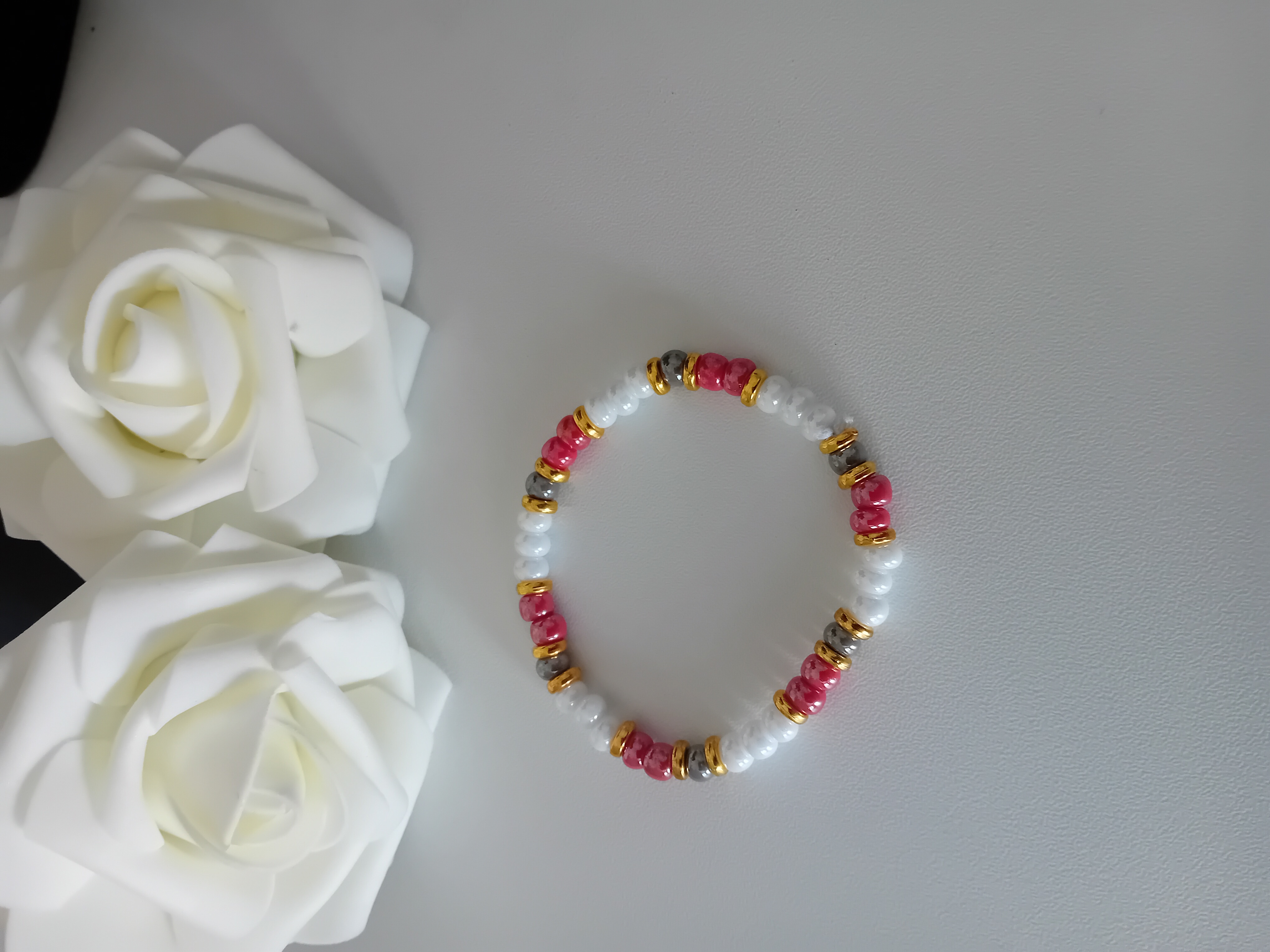 Bracelet en perles colorées. Bijou élégant aux tons rouges et dorés.