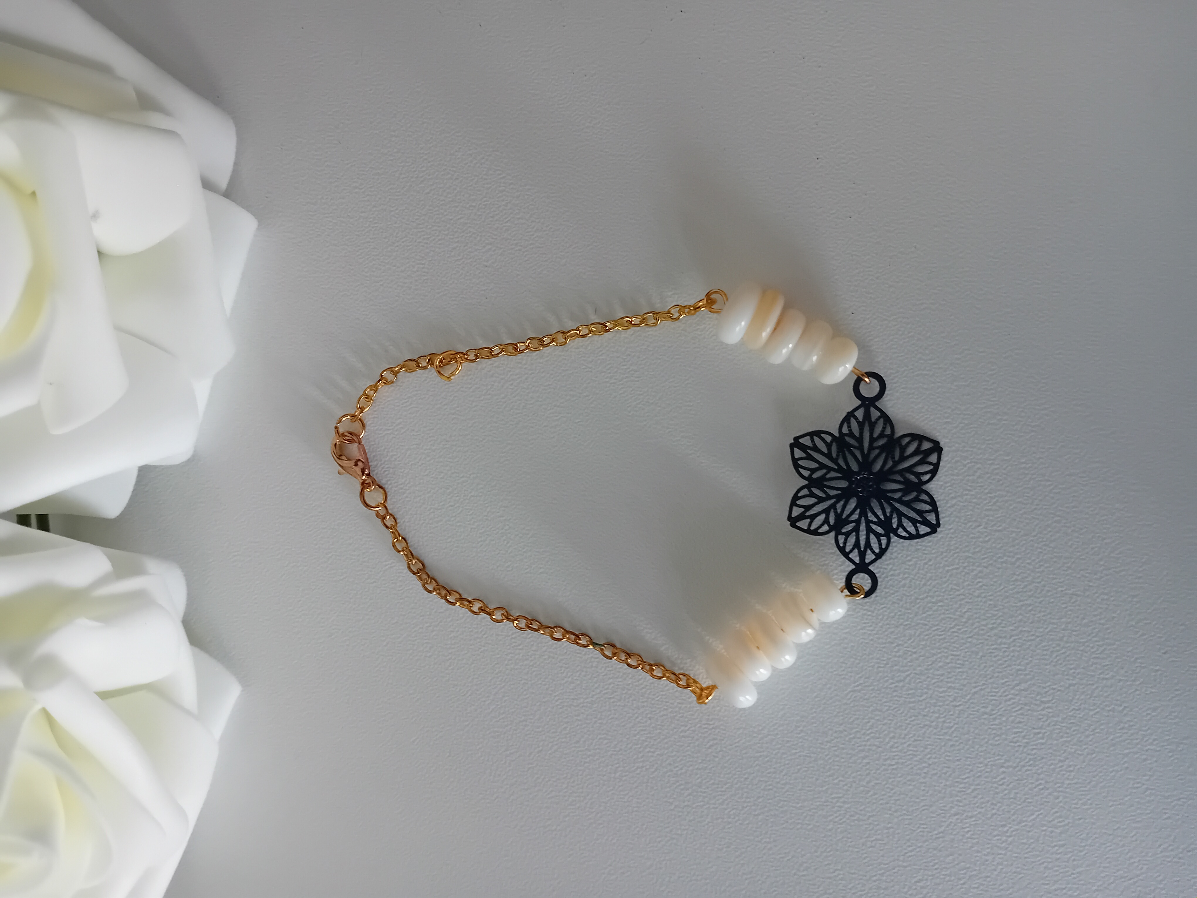 Bracelet en perles et fleur noire. Elégance délicate avec chaîne dorée et perles nacrées.