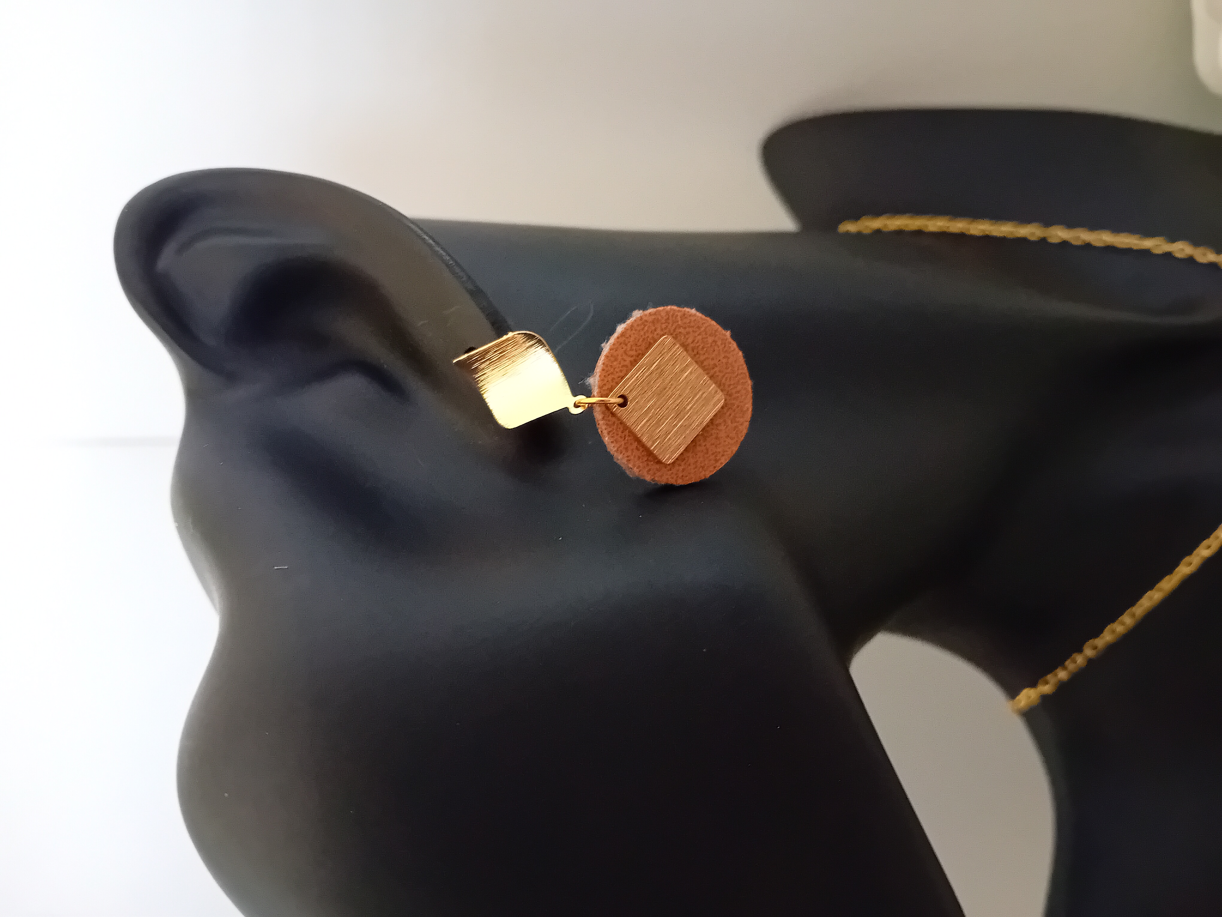 Boucle d’oreille en cuir et métal doré. Accessoire chic.