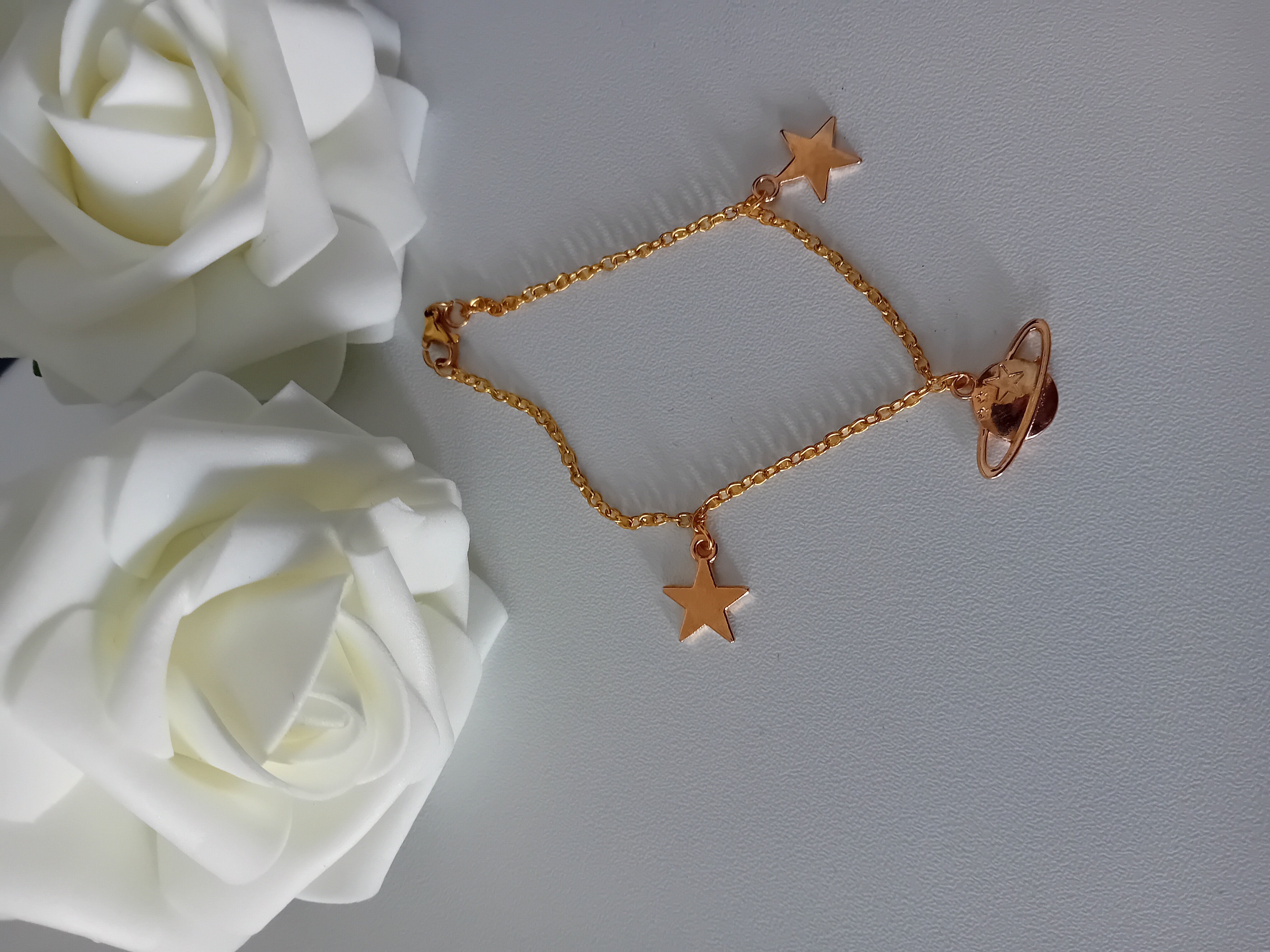 Bracelet doré étoile et planète. Bijou raffiné pour une touche céleste.