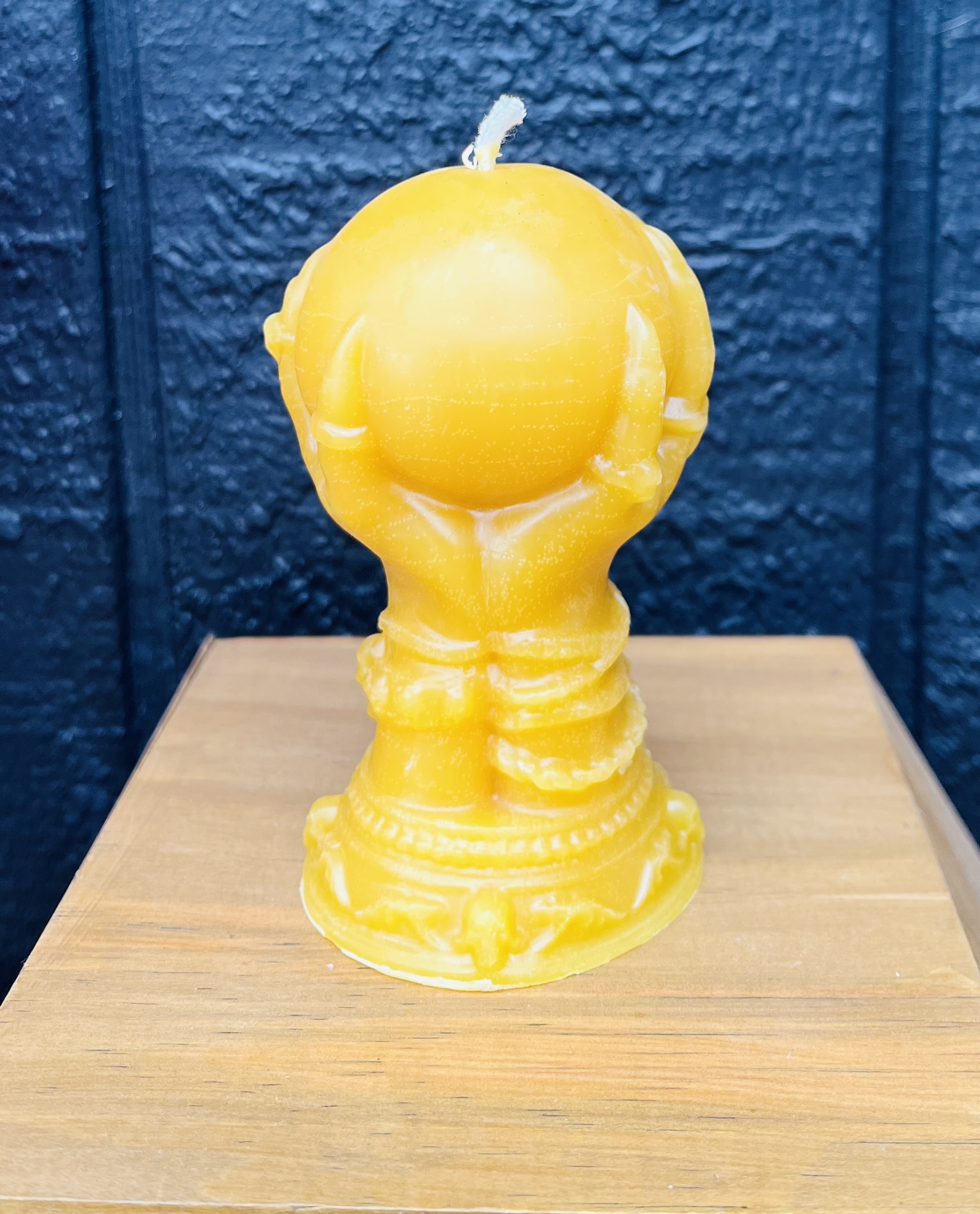 Hand holding ball beeswax candle