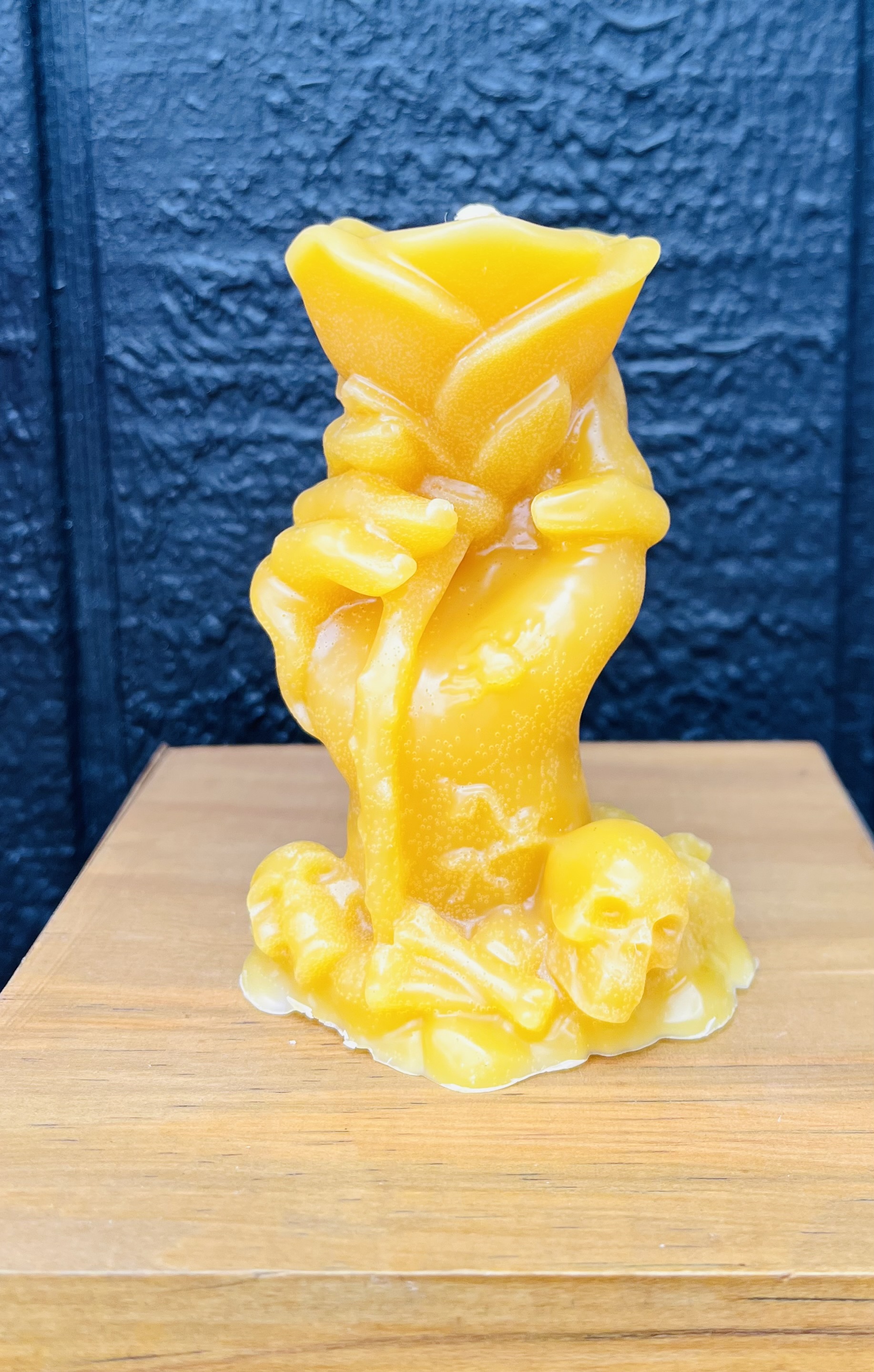 Hand holding rose beeswax candle