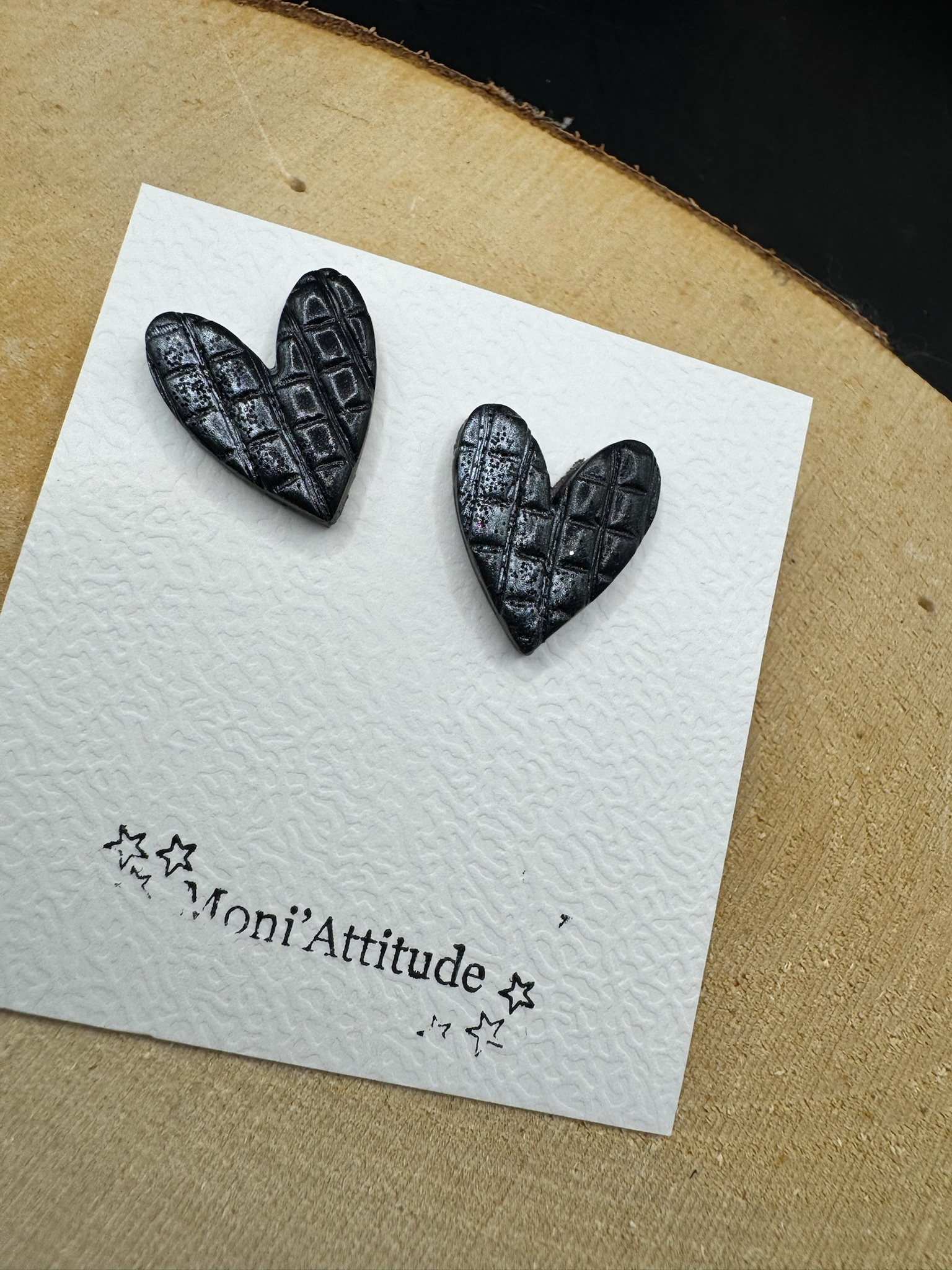 Boucles d’oreilles cœur noir effet matelassé argenté.