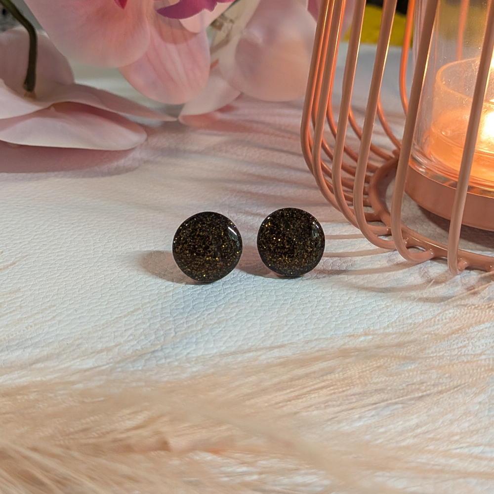 Musta-kultaglitter nappikorvikset