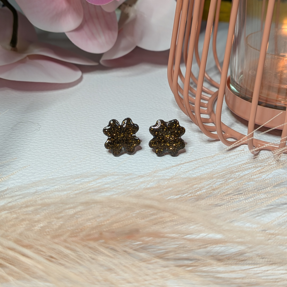 Musta-kultaglitter nappikorvikset