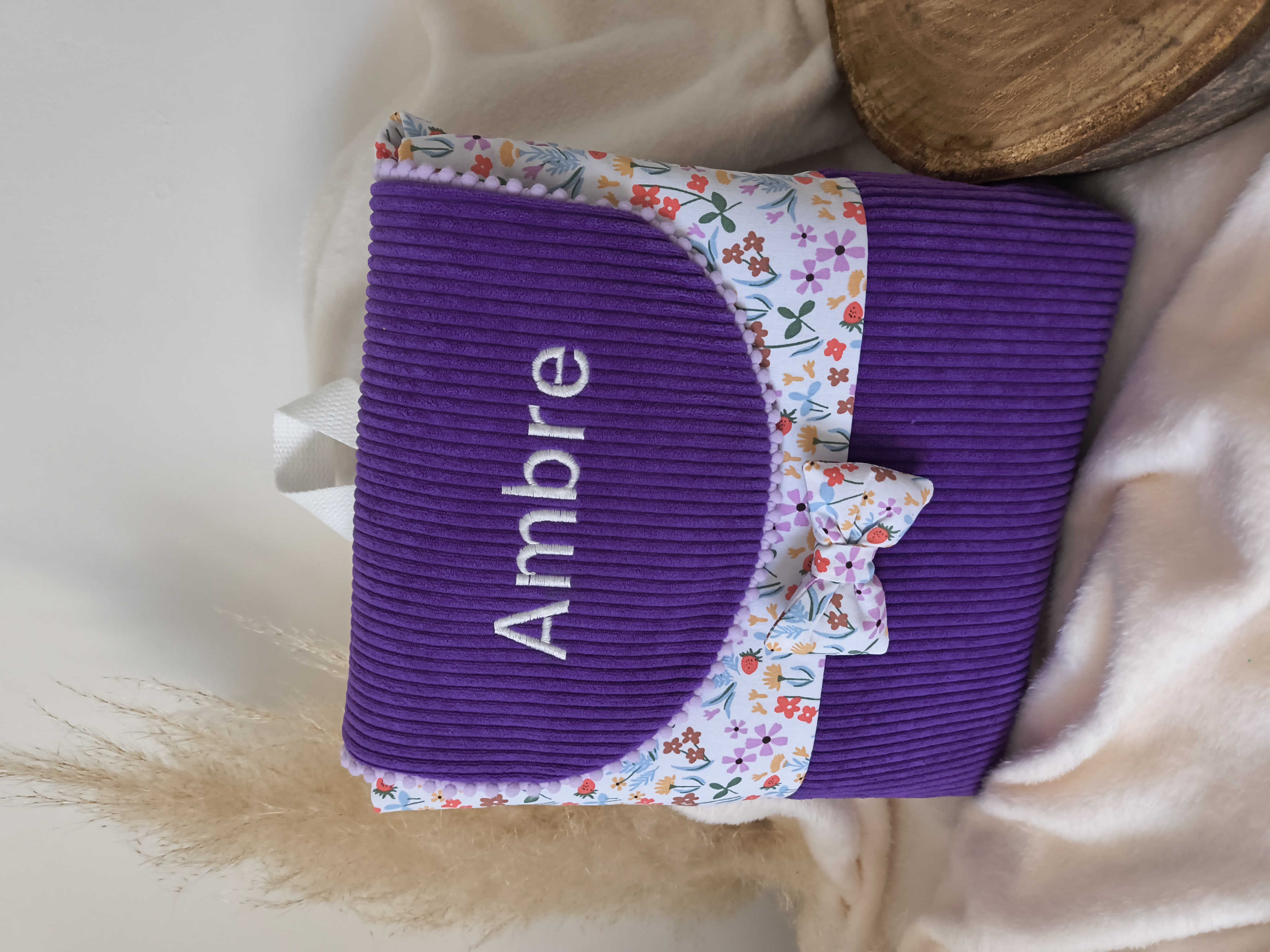 Sac à dos violet avec nœud fleuri et prénom brodé